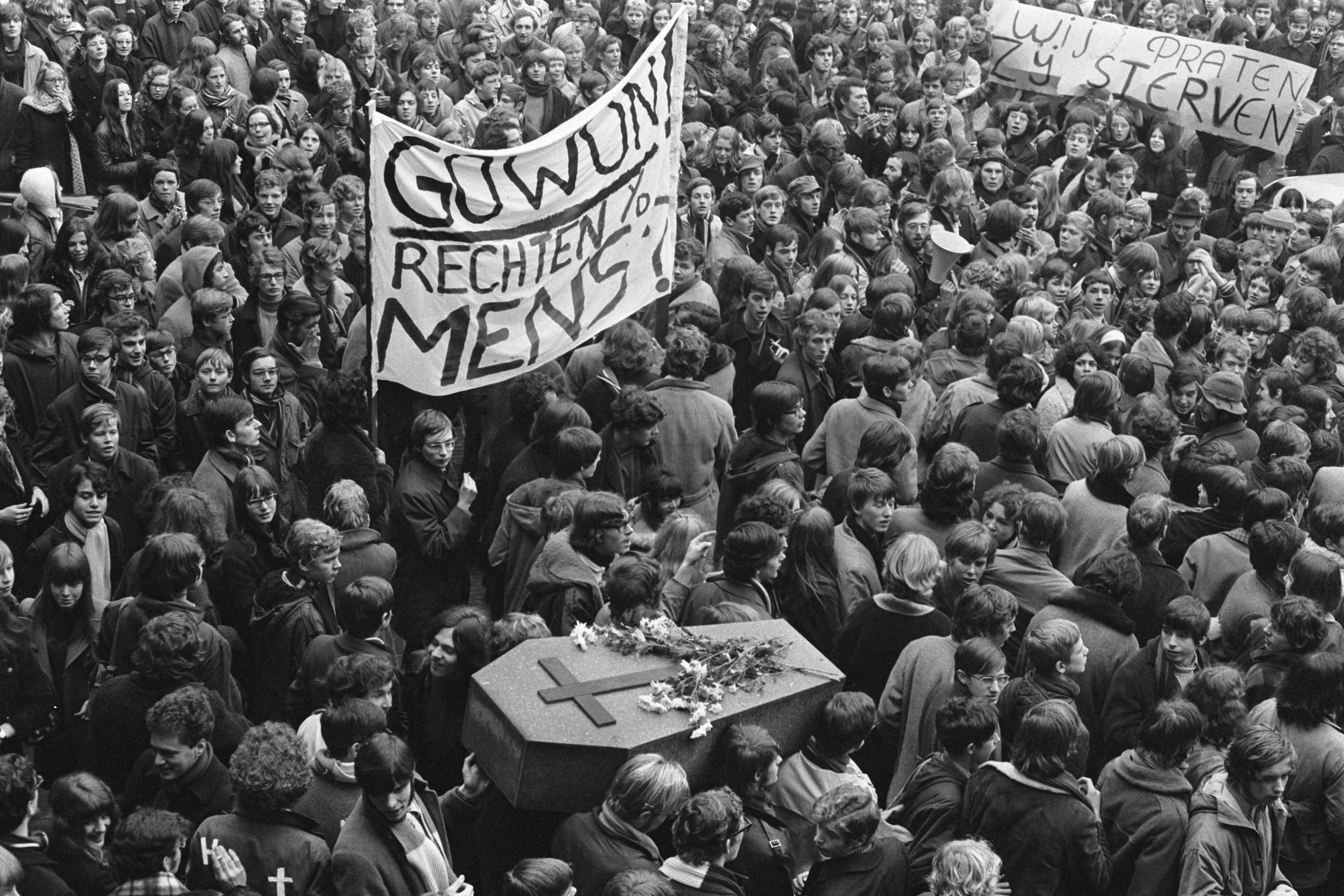 Fotocollectie Anefo — Protestmars van duizenden scholieren en studenten voor hulp aan Biafra, Den Haag . Demonstranten met doodskist en spandoeken op Binnenhof — Foto: Evers, Joost / Anefo. Licentie: Set B: Rechtenvrij / Publiek Domein. Bron: Nationaal Archief. http://hdl.handle.net/10648/ab896404-d0b4-102d-bcf8-003048976d84