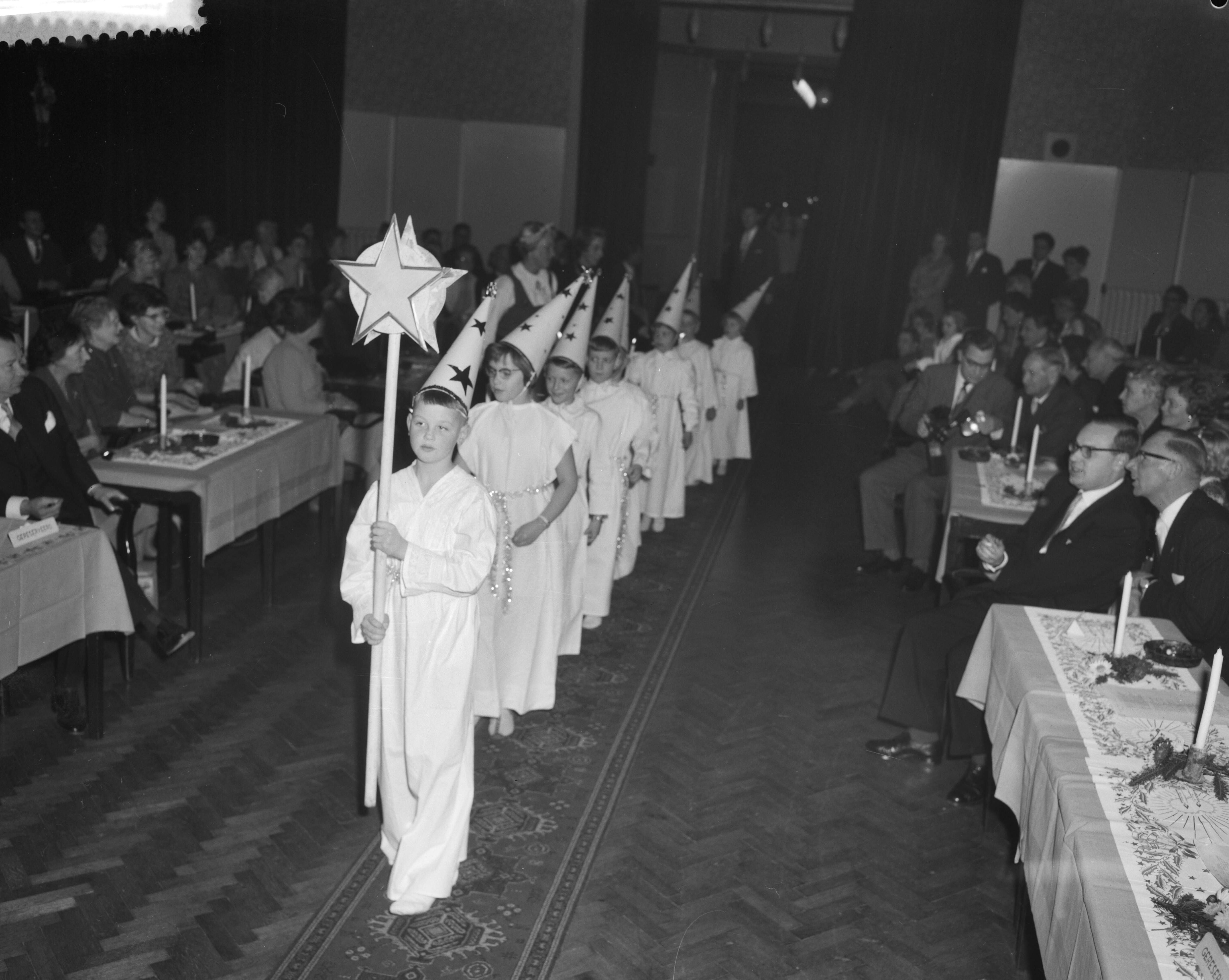 Fotocollectie Anefo — Viering van het Luciafeest door de Zweeds Nederlandse Vereniging in de Dierentuin te Den Haag. Binnenkomst van de "sterrejongens' — Foto: Behrens, Herbert F. / Anefo. Licentie: Set B: Rechtenvrij / Publiek Domein. Bron: Nationaal Archief. http://hdl.handle.net/10648/a9a3ac80-d0b4-102d-bcf8-003048976d84