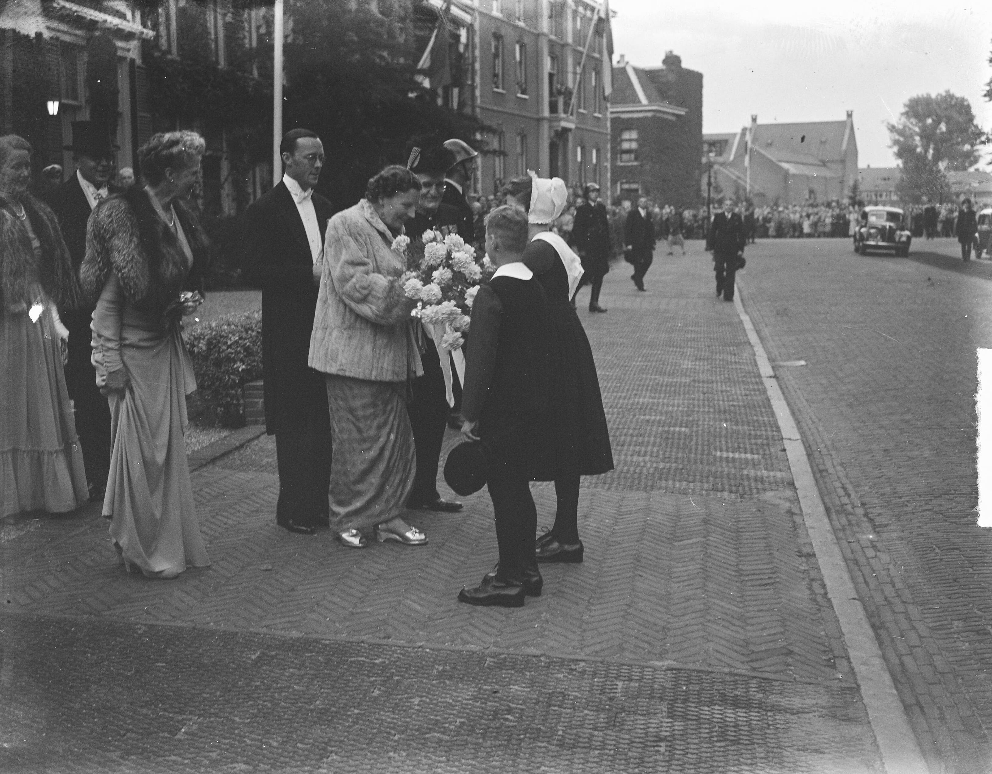 Fotocollectie Anefo — Koningin Juliana en prins Bernhard in Haarlem. De koningin krijgt bloemen aangeboden — Foto: Bilsen, Joop van / Anefo. Licentie: Set B: Rechtenvrij / Publiek Domein. Bron: Nationaal Archief. http://hdl.handle.net/10648/a8cb1a78-d0b4-102d-bcf8-003048976d84