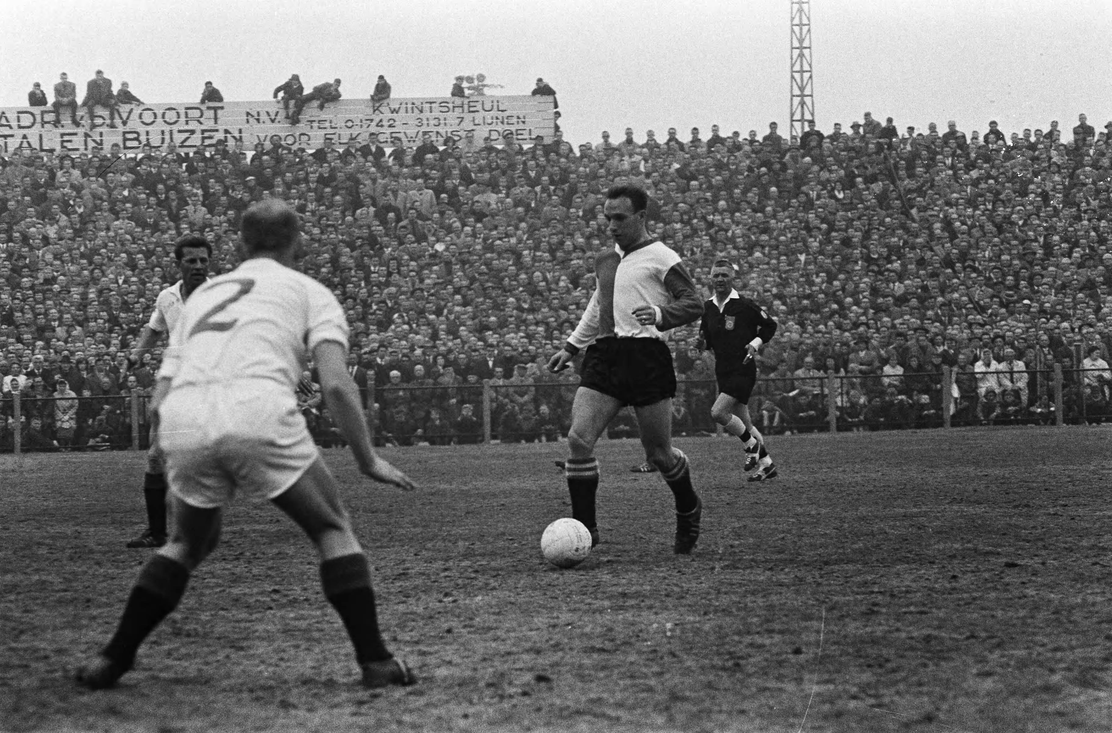 Fotocollectie Anefo — Voetbal. ADO tegen Feijenoord 1-1. Spelmoment, Rinus Bennaars aan de bal, op de rug gezien Jan Verhoek (ADO), Links Guus Haak — Foto: Koch, Eric / Anefo. Licentie: Set B: Rechtenvrij / Publiek Domein. Bron: Nationaal Archief. http://hdl.handle.net/10648/aa342904-d0b4-102d-bcf8-003048976d84
