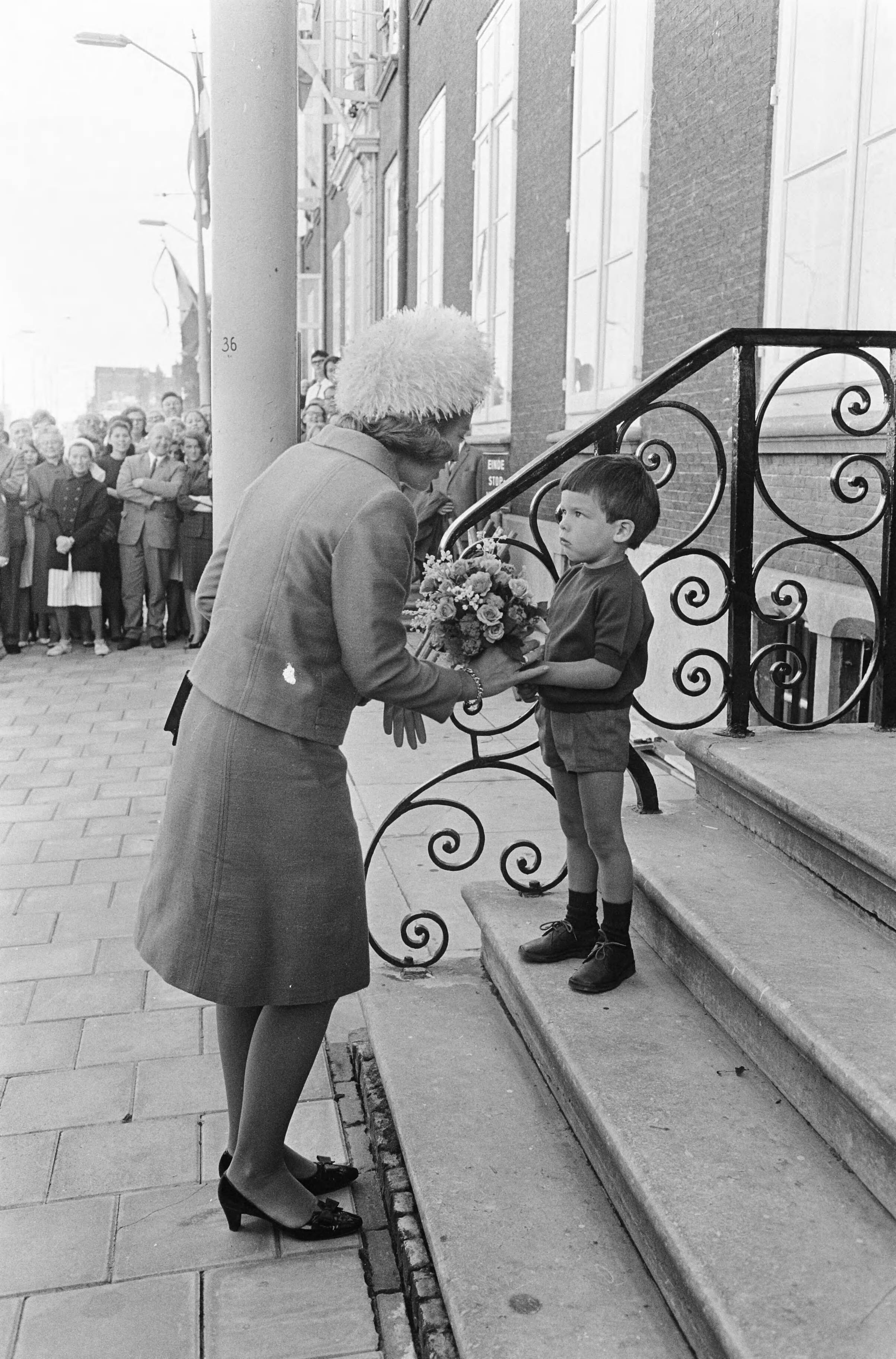 Prinses Beatrix lid van het Koninklijk instituut van Ingenieurs te Den Haag — Bij aankomst bood de 3 jarige Bastiaan Maris de prinses bloemen aan — Foto: Fotograaf Onbekend / Anefo. Licentie: Set B: Rechtenvrij / Publiek Domein. Bron: Nationaal Archief. http://hdl.handle.net/10648/aafbdba2-d0b4-102d-bcf8-003048976d84