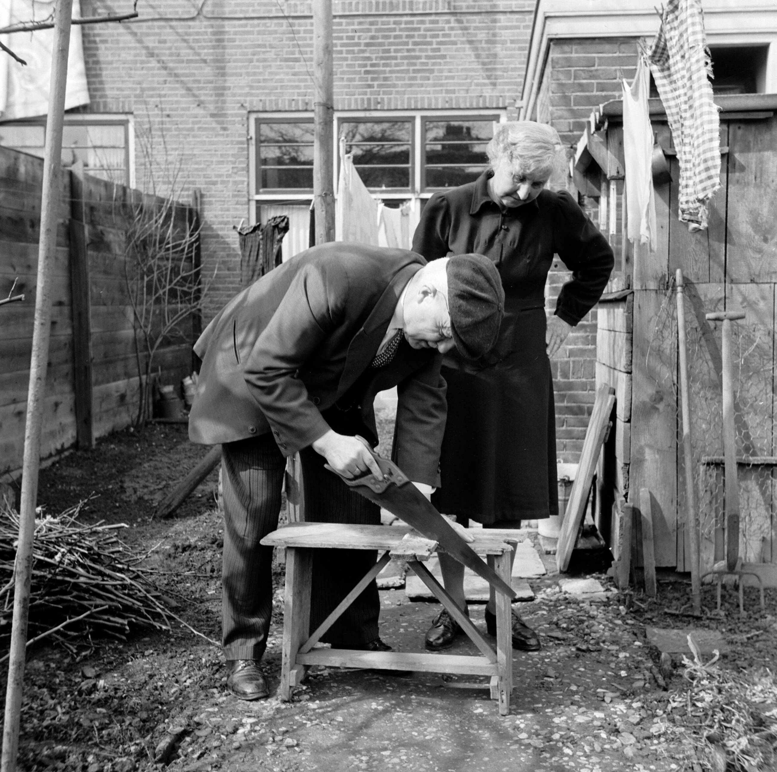 Fotocollectie Van de Poll — Het echtpaar S. de Jong in de tuin achter hun woning in het Friese Huizum (nu deel van Leeuwarden) — Foto: Poll, Willem van de. Licentie: Set B: Rechtenvrij / Publiek Domein. Bron: Nationaal Archief. http://hdl.handle.net/10648/aeccc674-d0b4-102d-bcf8-003048976d84