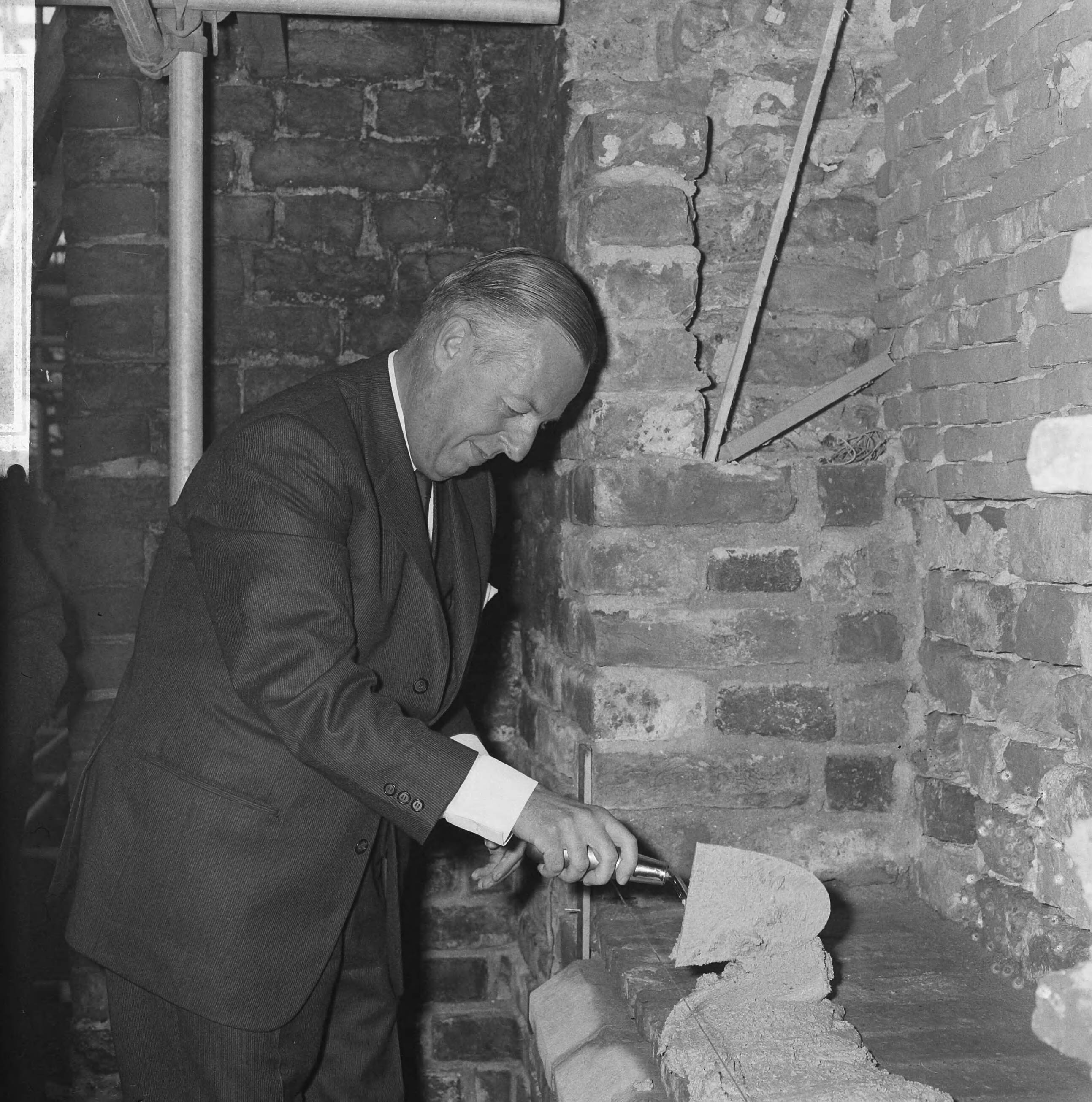 Restauratie van de oude dorpskerk te Voorburg — De burgemeester van Voorburg, jhr.mr. A. Feith, bij het metselen van de eerste steen, waarmee hij de restauratie in gang zette — Foto: Kroon, Ron / Anefo. Licentie: Set B: Rechtenvrij / Publiek Domein. Bron: Nationaal Archief. http://hdl.handle.net/10648/aacbb56c-d0b4-102d-bcf8-003048976d84