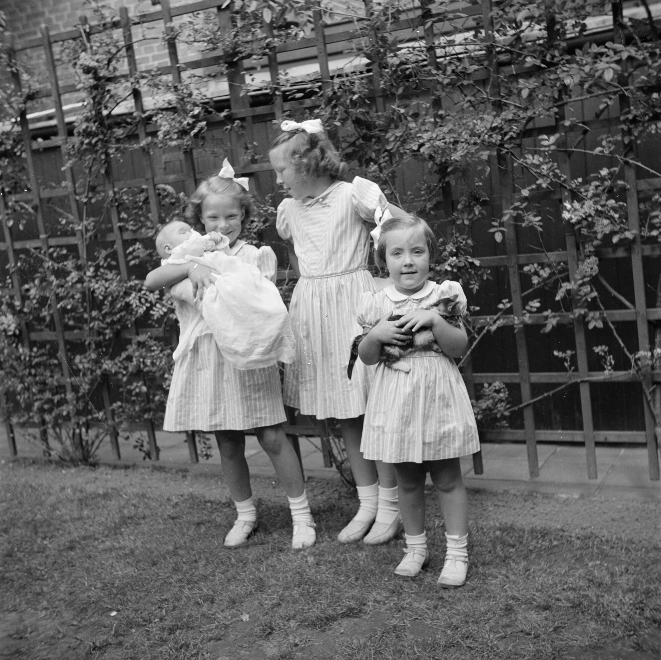 Het prinselijk gezin in Friesland — Prinses Beatrix, prinses Irene met prinses Christina in haar armen en prinses Margriet met een kat in haar armen — Foto: Poll, Willem van de. Licentie: Set B: Rechtenvrij / Publiek Domein. Bron: Nationaal Archief. http://hdl.handle.net/10648/aee82cac-d0b4-102d-bcf8-003048976d84