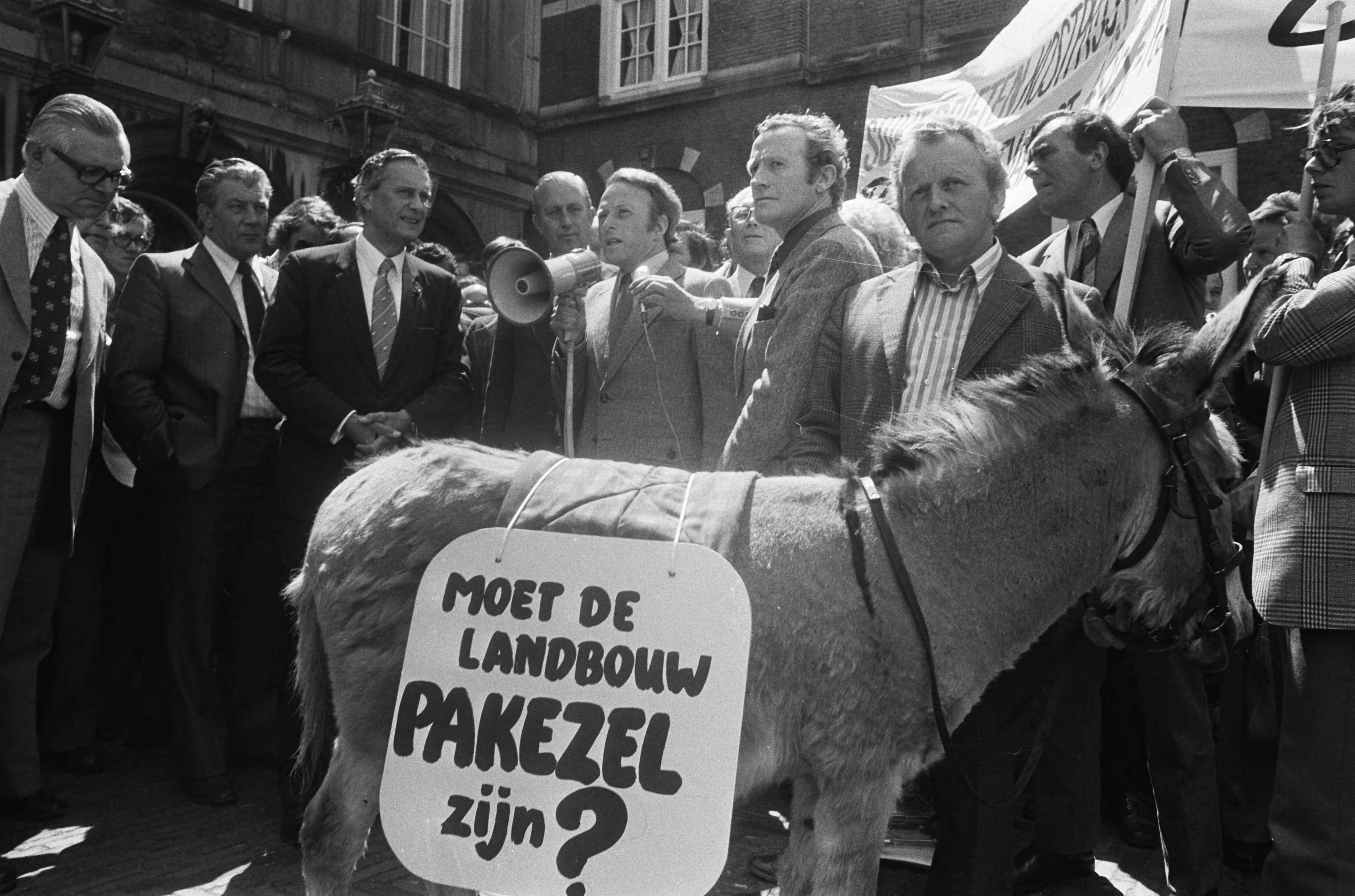 Demonstratie in Den Haag van boeren en tuinders voor betere sociale maatregelen — Ezel met spandoek op het Binnenhof — Foto: Peters, Hans / Anefo. Licentie: Set B: Rechtenvrij / Publiek Domein. Bron: Nationaal Archief. http://hdl.handle.net/10648/ac6b32b2-d0b4-102d-bcf8-003048976d84