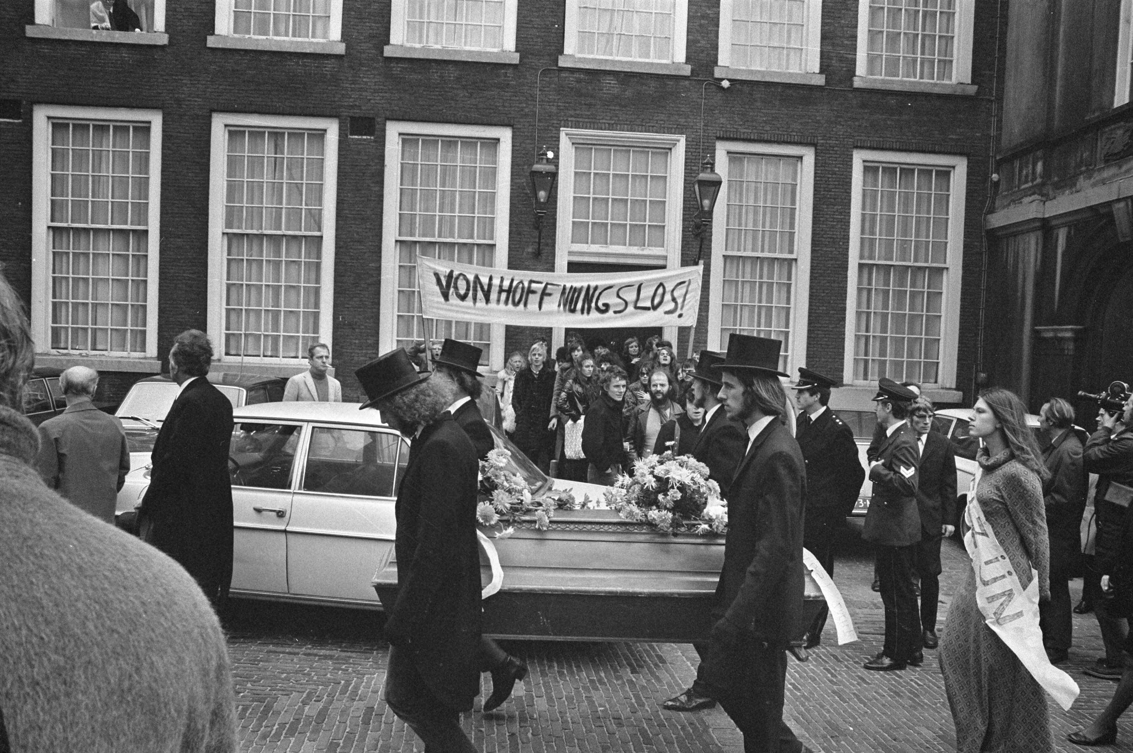 Fotocollectie Anefo — Demonstratie van anti-CRM bezuinigingsfront met doodkist Binnenhof Den Haag , begrafenisstoet met kist en spandoek — Foto: Evers, Joost / Anefo. Licentie: Set B: Rechtenvrij / Publiek Domein. Bron: Nationaal Archief. http://hdl.handle.net/10648/abd74d40-d0b4-102d-bcf8-003048976d84