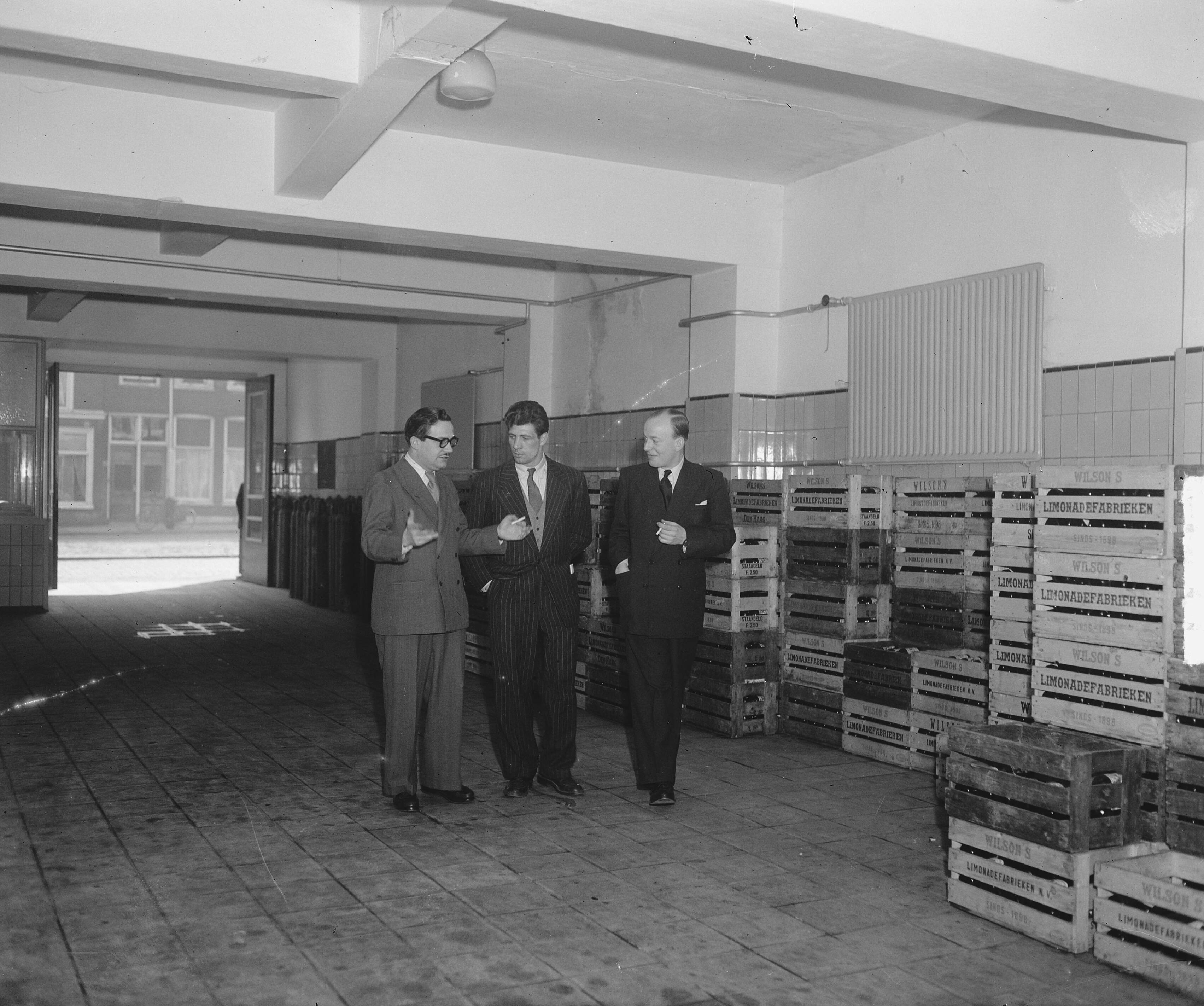 Fotocollectie Anefo — Luc van Dam (bokser) werkzaam in limonadefabriek — Foto: Averink, […] / Anefo. Licentie: Set B: Rechtenvrij / Publiek Domein. Bron: Nationaal Archief. http://hdl.handle.net/10648/a8c51fce-d0b4-102d-bcf8-003048976d84