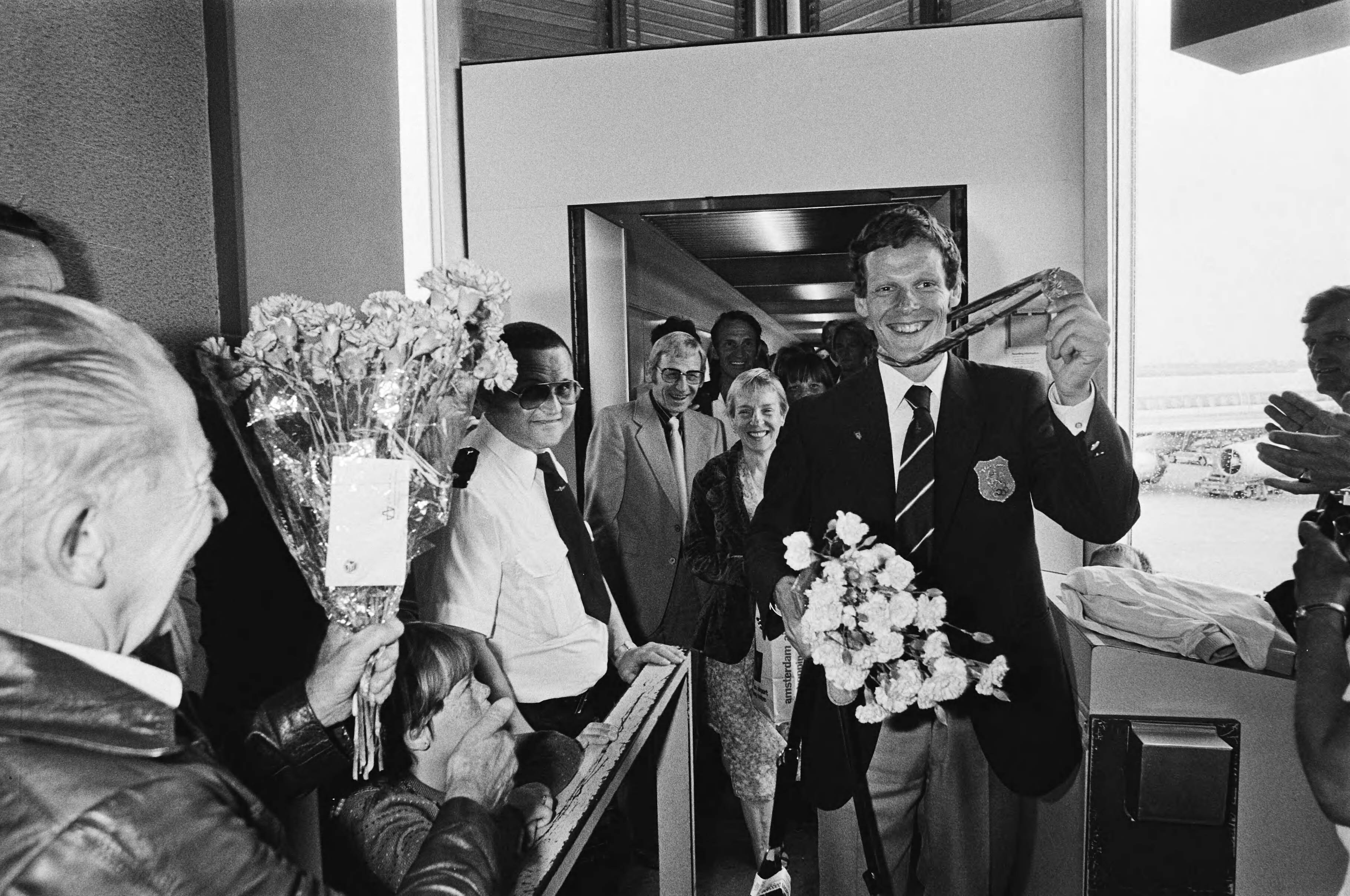 Aankomst van de Nederlandse Olympische ploeg uit Moskou op Schiphol — Gerard Nijboer zwaaiend met zijn medaille — Foto: Dijk, Hans van / Anefo. Licentie: Set B: Rechtenvrij / Publiek Domein. Bron: Nationaal Archief. http://hdl.handle.net/10648/ace4f386-d0b4-102d-bcf8-003048976d84