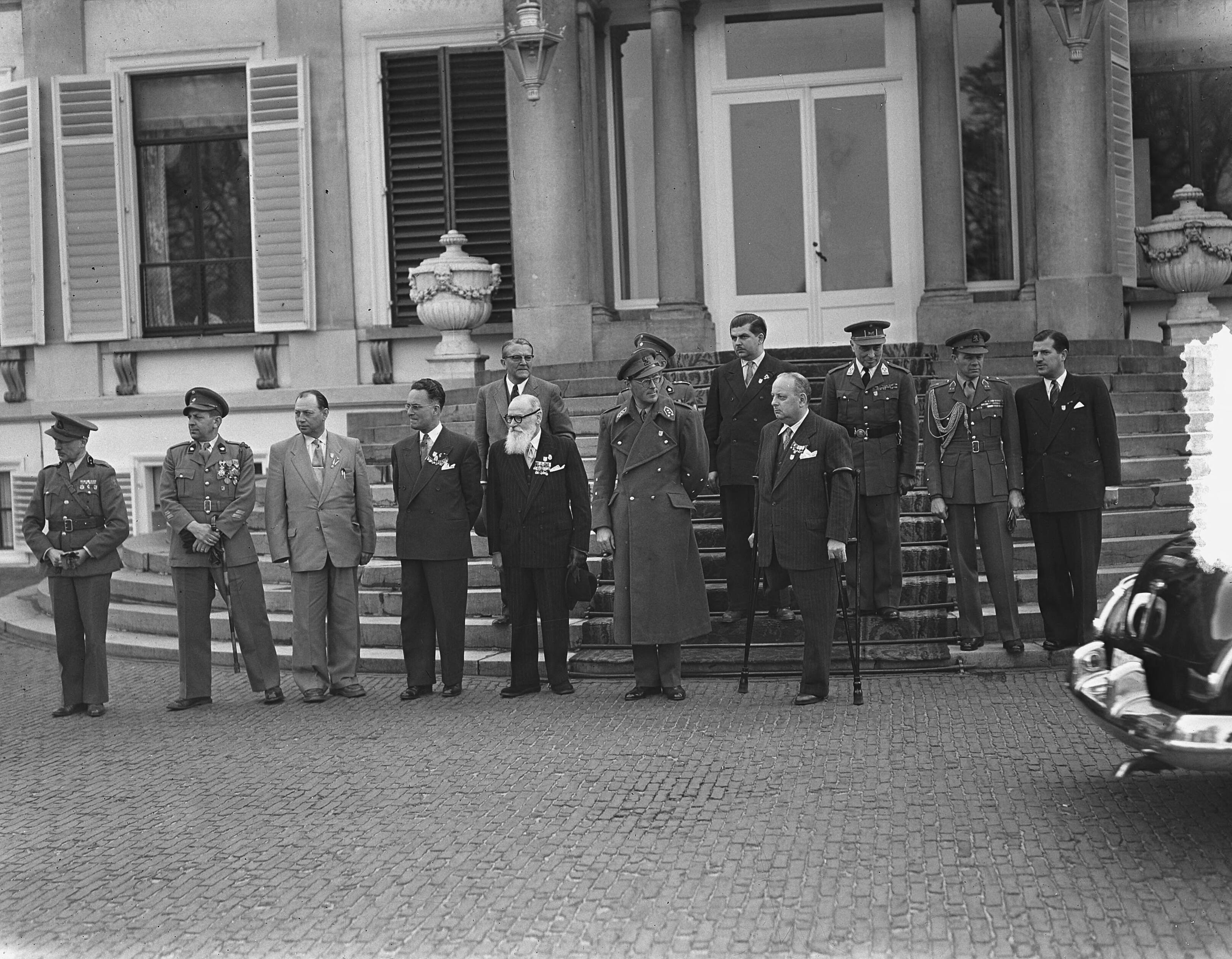 Fotocollectie Anefo — Ontvangst M.O.V.E.O. op Soestdijk. Prins Bernhard neemt het defilé (van auto's) af, in gezelschap van bestuursleden en delegatieleiders — Foto: Bilsen, Joop van / Anefo. Licentie: Set B: Rechtenvrij / Publiek Domein. Bron: Nationaal Archief. http://hdl.handle.net/10648/a9217396-d0b4-102d-bcf8-003048976d84