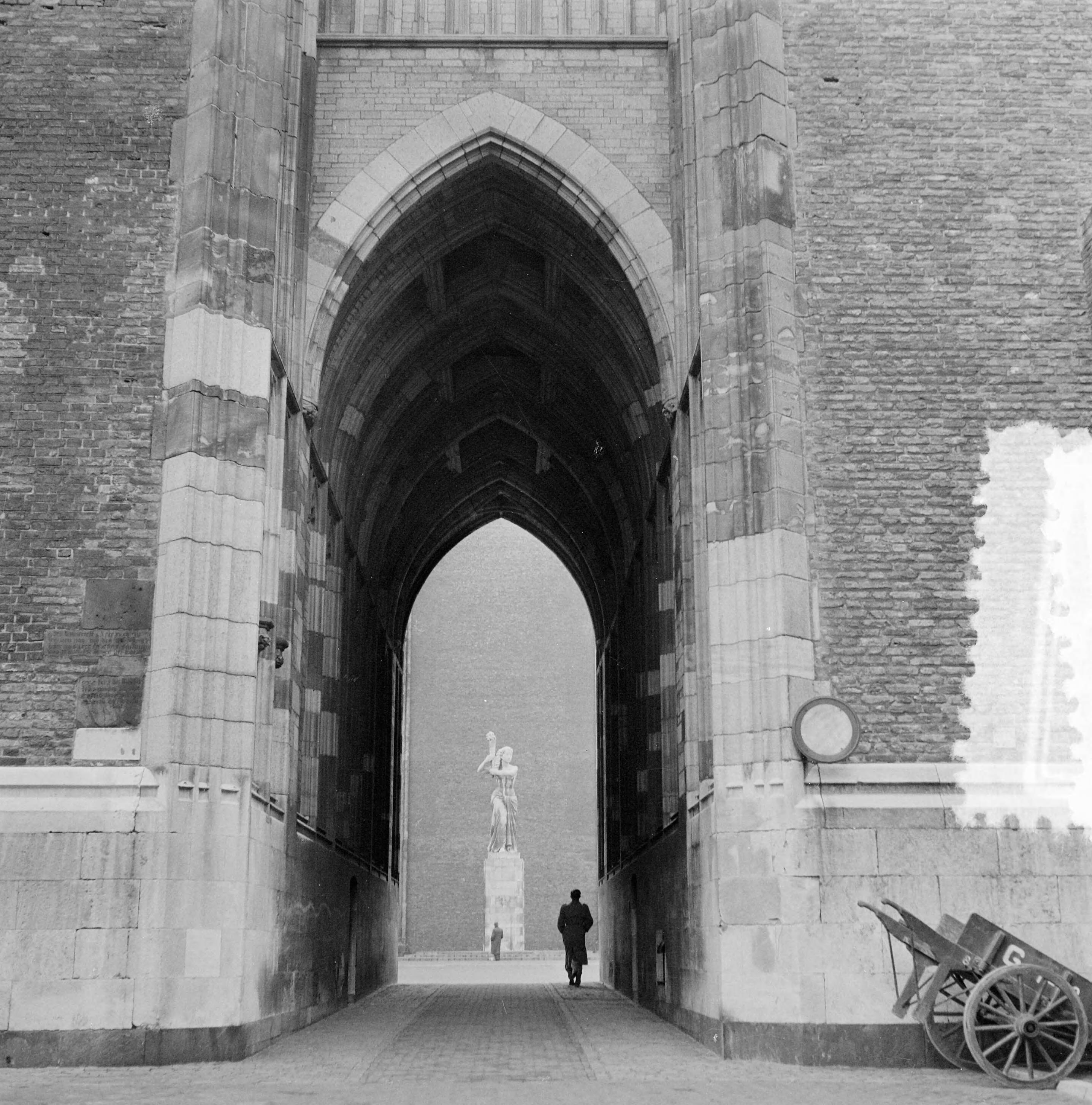 Stadsgezichten Utrecht — Stadsgezichten Utrecht. Doorkijk Dom met zicht op verzetsmonument op het Domplein — Foto: Noske, J.D. / Anefo. Licentie: Set B: Rechtenvrij / Publiek Domein. Bron: Nationaal Archief. http://hdl.handle.net/10648/a91b75ea-d0b4-102d-bcf8-003048976d84