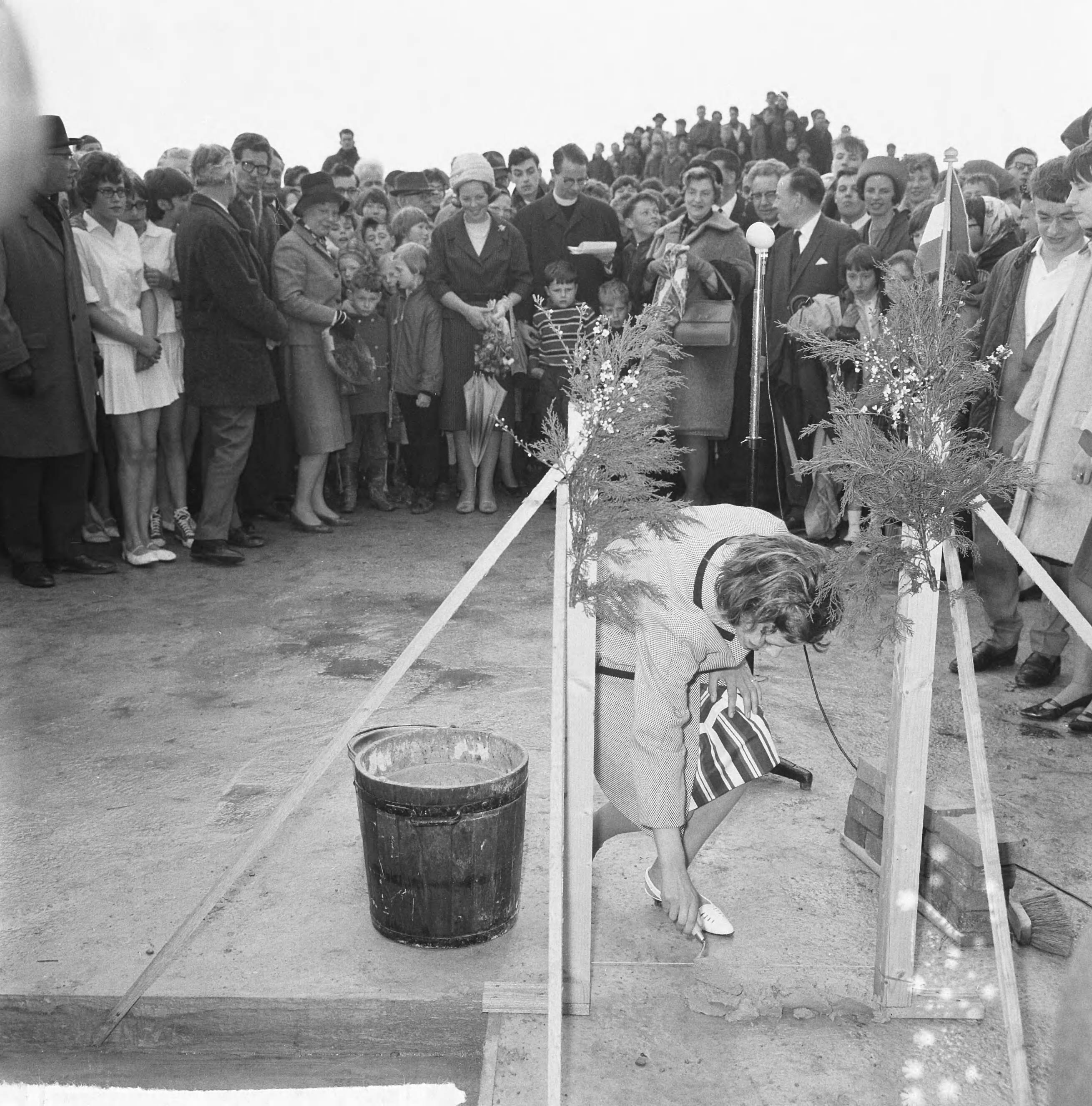Fotocollectie Anefo — Prinses Beatrix was aanwezig bij de eerste steenlegging voor het jongerenontmoetingscentrum "Het Zilveren Schor" nabij Arnemuiden. Naast de prinses, de voorzitter van de Stichting Zilveren Jeugdcentra, pater W.A.M. Alting von Geusau. De eerste stenen werden gemetseld door twee schoolmeisjes uit Arnemuiden, Janna Schets en Leuntje Schroevers, en twee jongens uit het zeehospitium in Oostkapelle, Dirk Albregtse en Wim Segeler. Een van de meisjes maakt een begin — Foto: Nijs, Jac. de / Anefo. Licentie: Set B: Rechtenvrij / Publiek Domein. Bron: Nationaal Archief. http://hdl.handle.net/10648/aaa1c36a-d0b4-102d-bcf8-003048976d84
