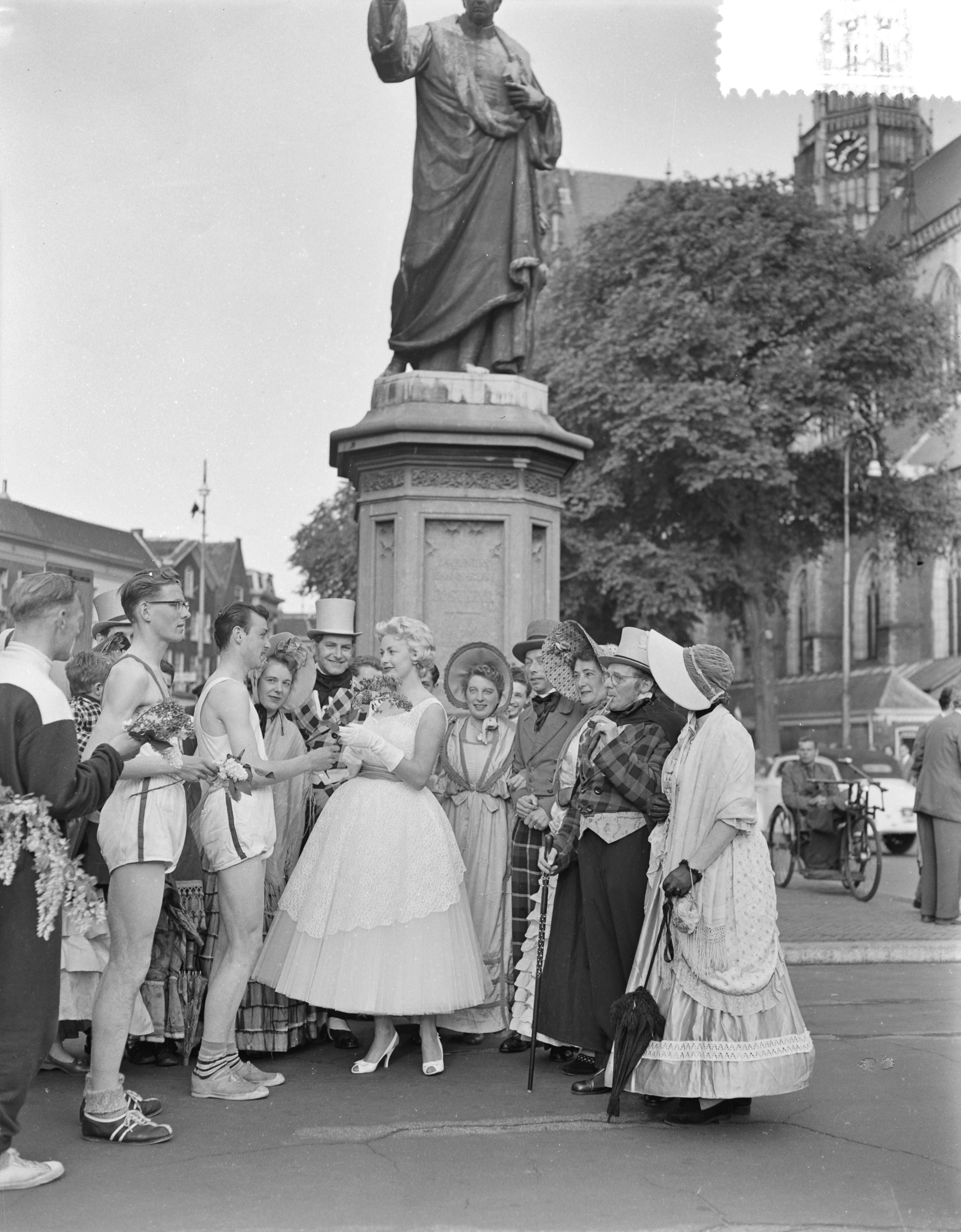 Fotocollectie Anefo — Feest seringenkoningin Haarlem. Zij ontving de eerste hulde van estafettelopers op de Grote Markt te Haarlem bij het standbeeld van Laurens Jansz. Coster — Foto: Pot, Harry / Anefo. Licentie: Set B: Rechtenvrij / Publiek Domein. Bron: Nationaal Archief. http://hdl.handle.net/10648/a9497ed6-d0b4-102d-bcf8-003048976d84