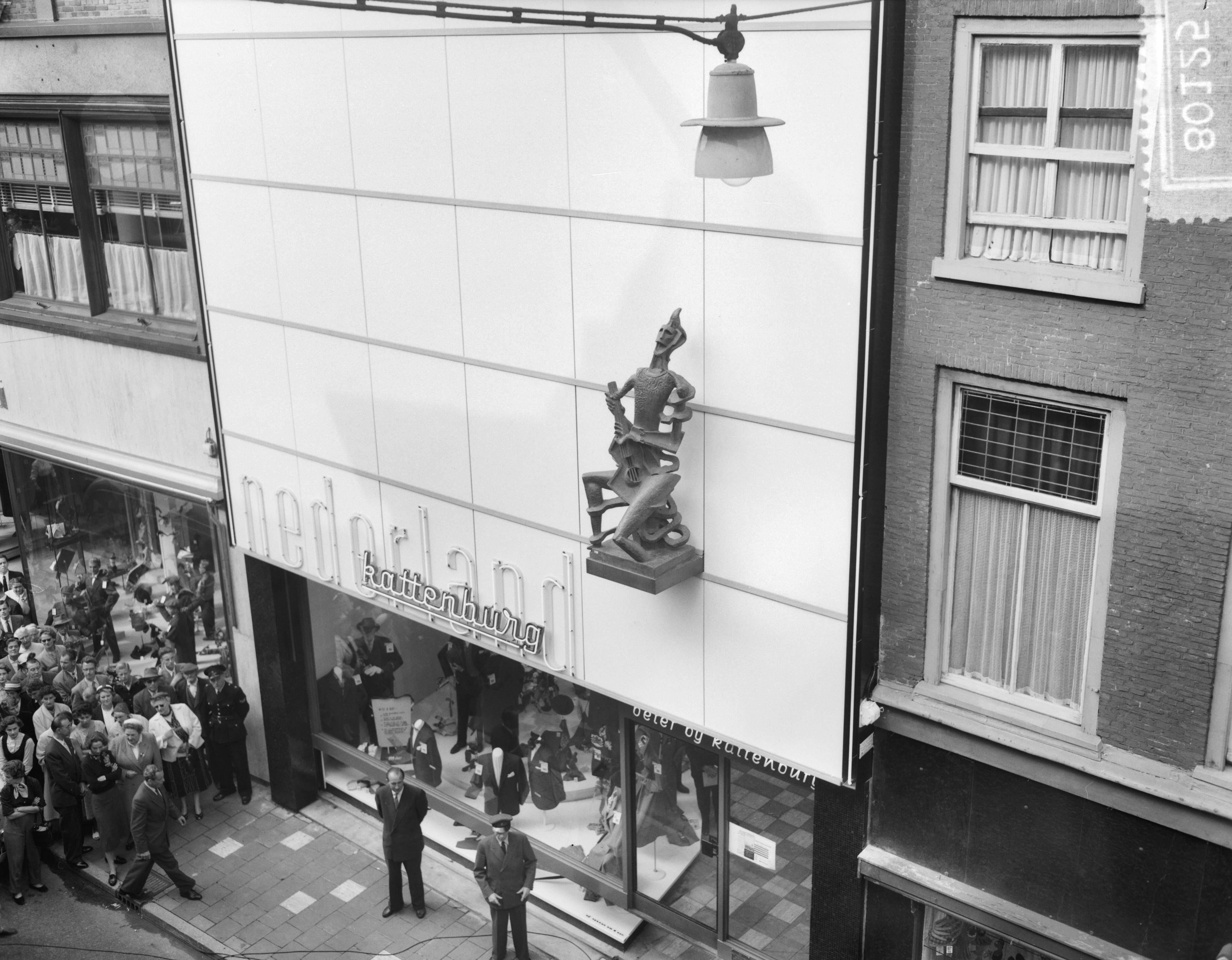 Fotocollectie Anefo — Onthulling beeld "De Harlekijn" van Ossip Zadkine op gevel van modehuis N.V. Kattenburg te Haarlem — Foto: Noske, J.D. / Anefo. Licentie: Set B: Rechtenvrij / Publiek Domein. Bron: Nationaal Archief. http://hdl.handle.net/10648/a94f3c5e-d0b4-102d-bcf8-003048976d84