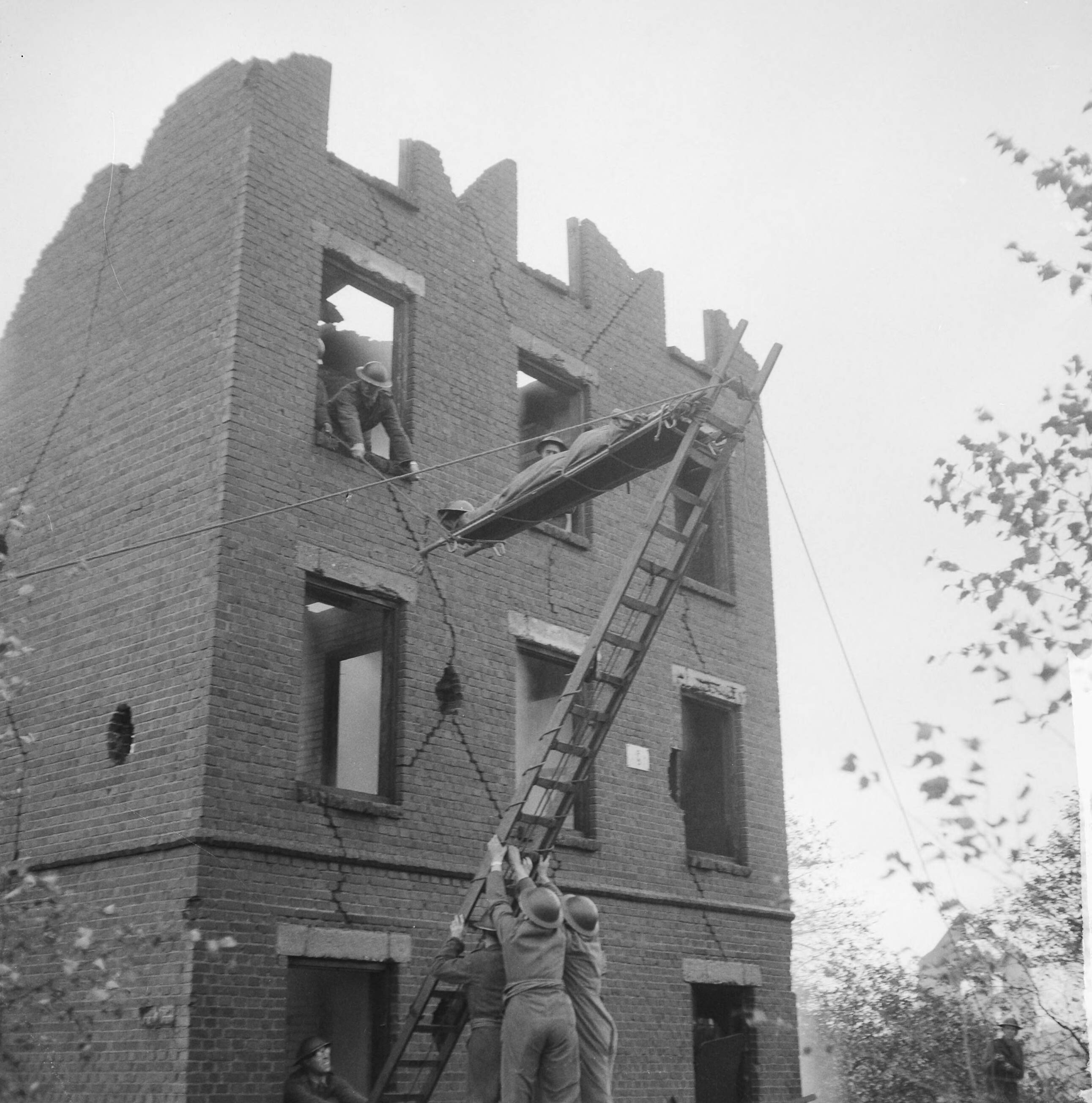 Fotocollectie Anefo — Oefening Korps Mobiele Colonnes in kamp Crailo bij Laren (N.H.), redding van gewonden uit huizen (opdracht Trouw) — Foto: Lindeboom, Henk / Anefo. Licentie: Set B: Rechtenvrij / Publiek Domein. Bron: Nationaal Archief. http://hdl.handle.net/10648/a9bdc00c-d0b4-102d-bcf8-003048976d84