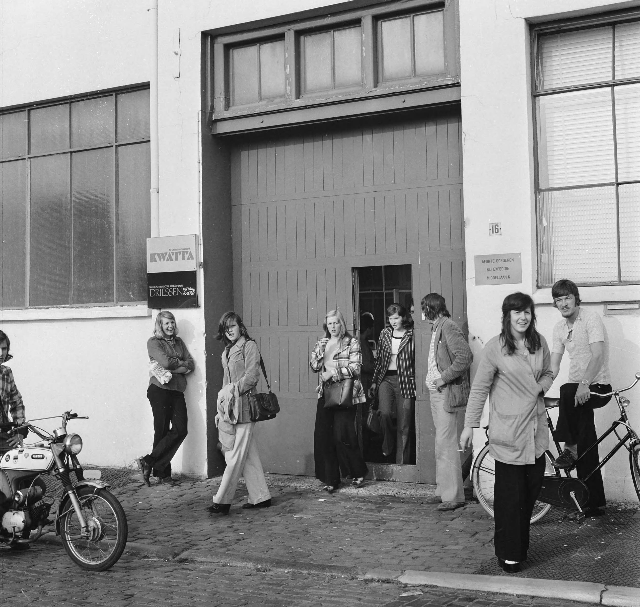 Fotocollectie Anefo — Kwatta-chocoladefabriek te Breda in moelijkheden, meisjes verlaten fabriek — Foto: Mieremet, Rob / Anefo. Licentie: Set B: Rechtenvrij / Publiek Domein. Bron: Nationaal Archief. http://hdl.handle.net/10648/ac36a2ae-d0b4-102d-bcf8-003048976d84