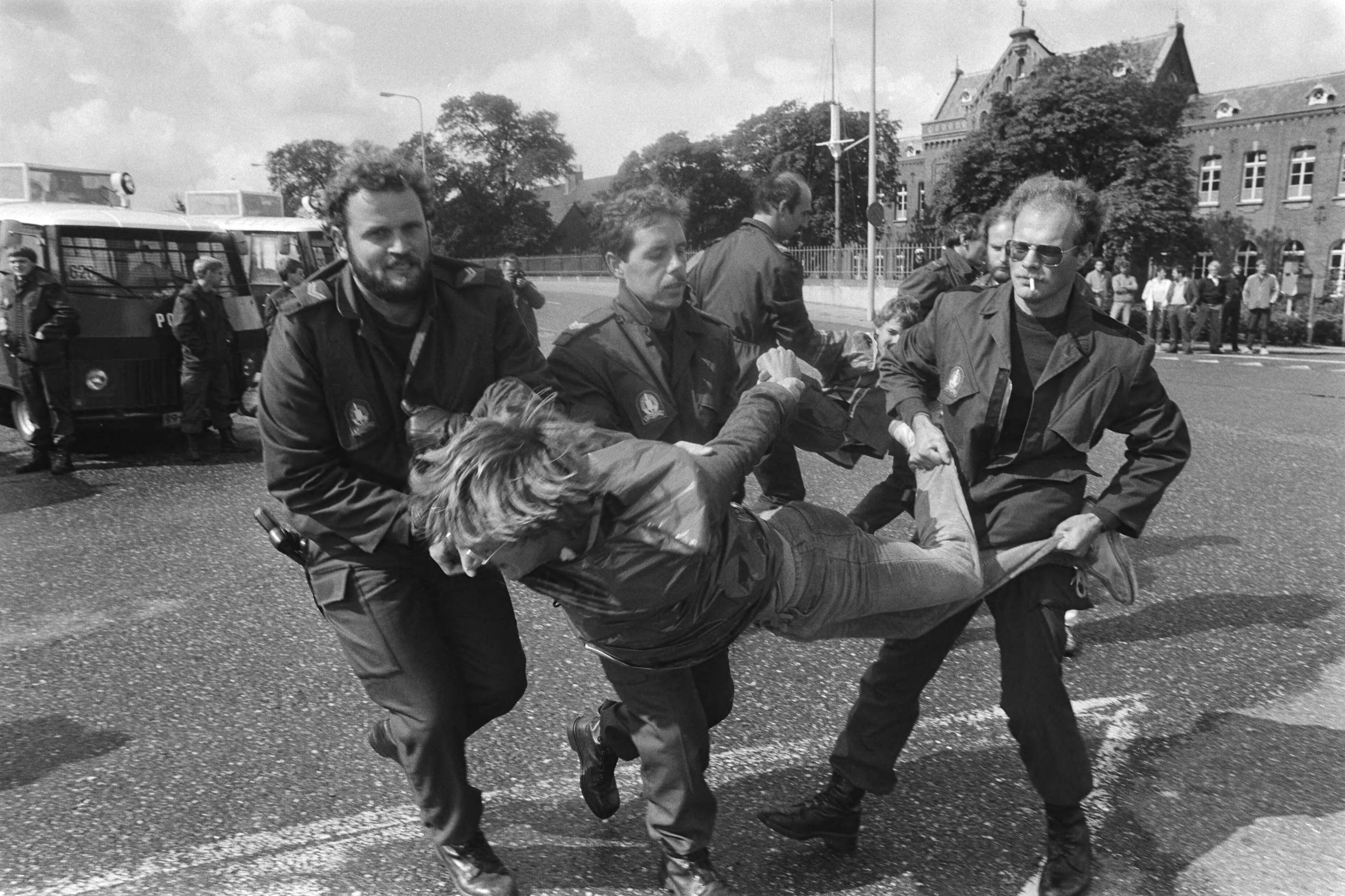 Fotocollectie Anefo — Akties tegen transport radioactief afval van Petten naar Den Helder ; ME-ers dragen aktievoerder weg — Foto: Dijk, Hans van / Anefo. Licentie: Set B: Rechtenvrij / Publiek Domein. Bron: Nationaal Archief. http://hdl.handle.net/10648/ad1ce868-d0b4-102d-bcf8-003048976d84