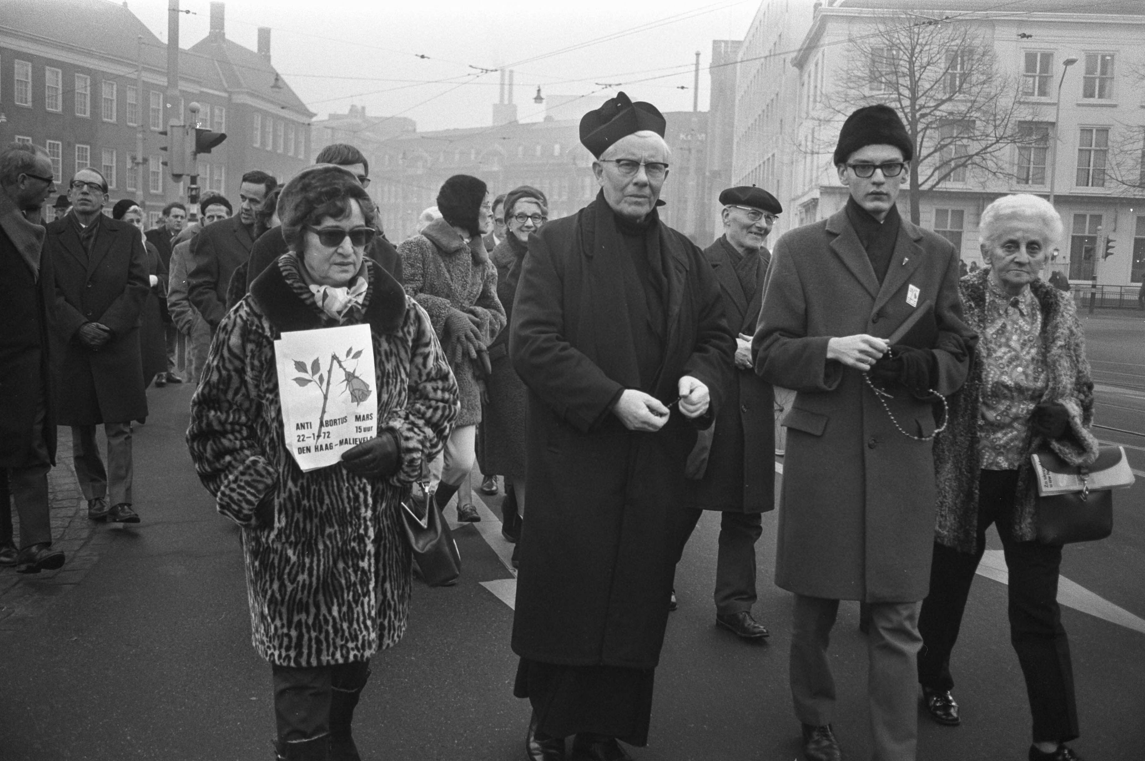 Fotocollectie Anefo — Anti-abortusmars in Den Haag , enige demonstranten (o.a. een pater) — Foto: Peters, Hans / Anefo. Licentie: Set B: Rechtenvrij / Publiek Domein. Bron: Nationaal Archief. http://hdl.handle.net/10648/abded5ba-d0b4-102d-bcf8-003048976d84