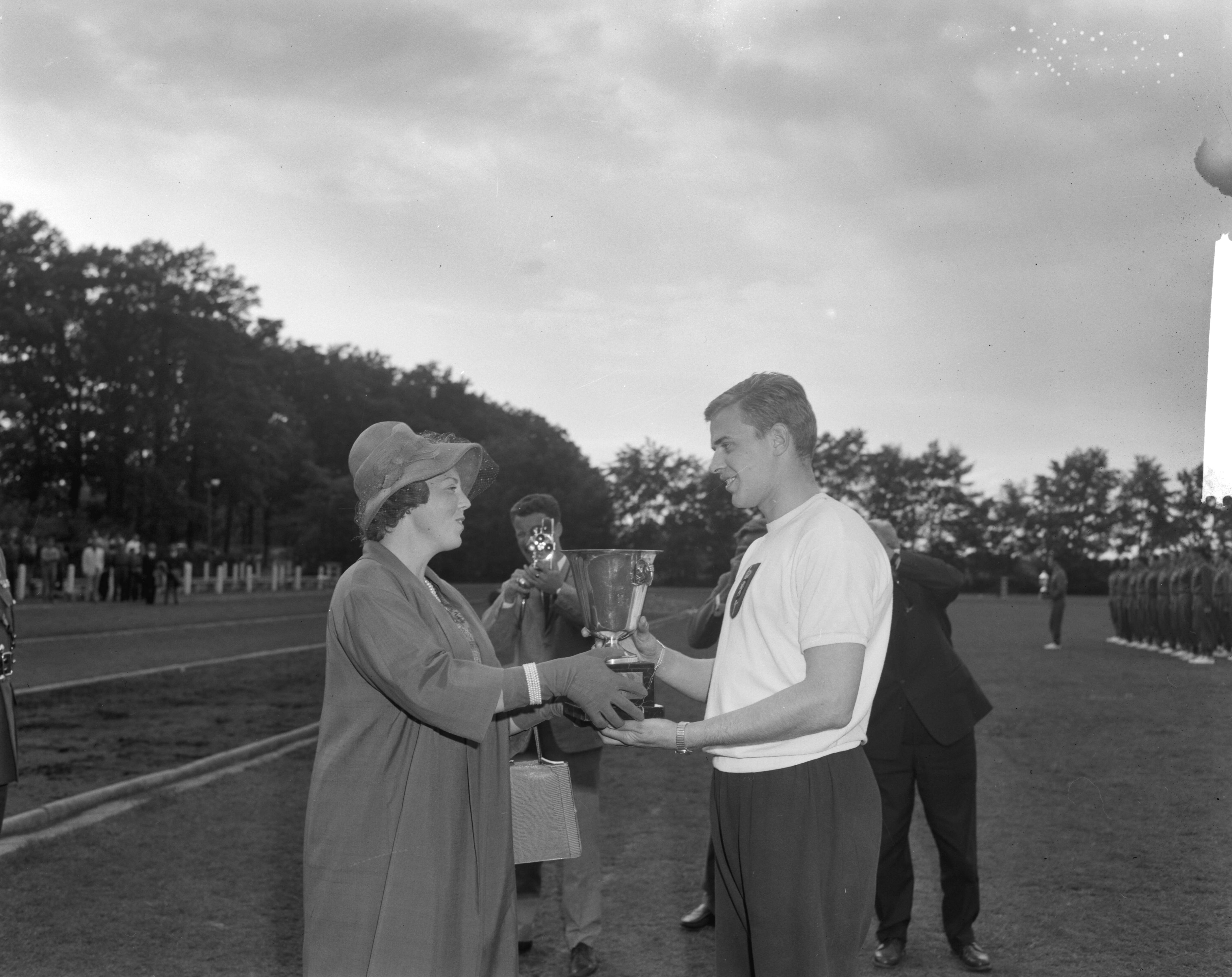 Fotocollectie Anefo — West-Europese kadetten-atletiekwedstrijden in Breda. Prinses Beatrix reikt, in plaats van prins Bernhard, een beker uit — Foto: Bilsen, Joop van / Anefo. Licentie: Set B: Rechtenvrij / Publiek Domein. Bron: Nationaal Archief. http://hdl.handle.net/10648/aa0cb43c-d0b4-102d-bcf8-003048976d84