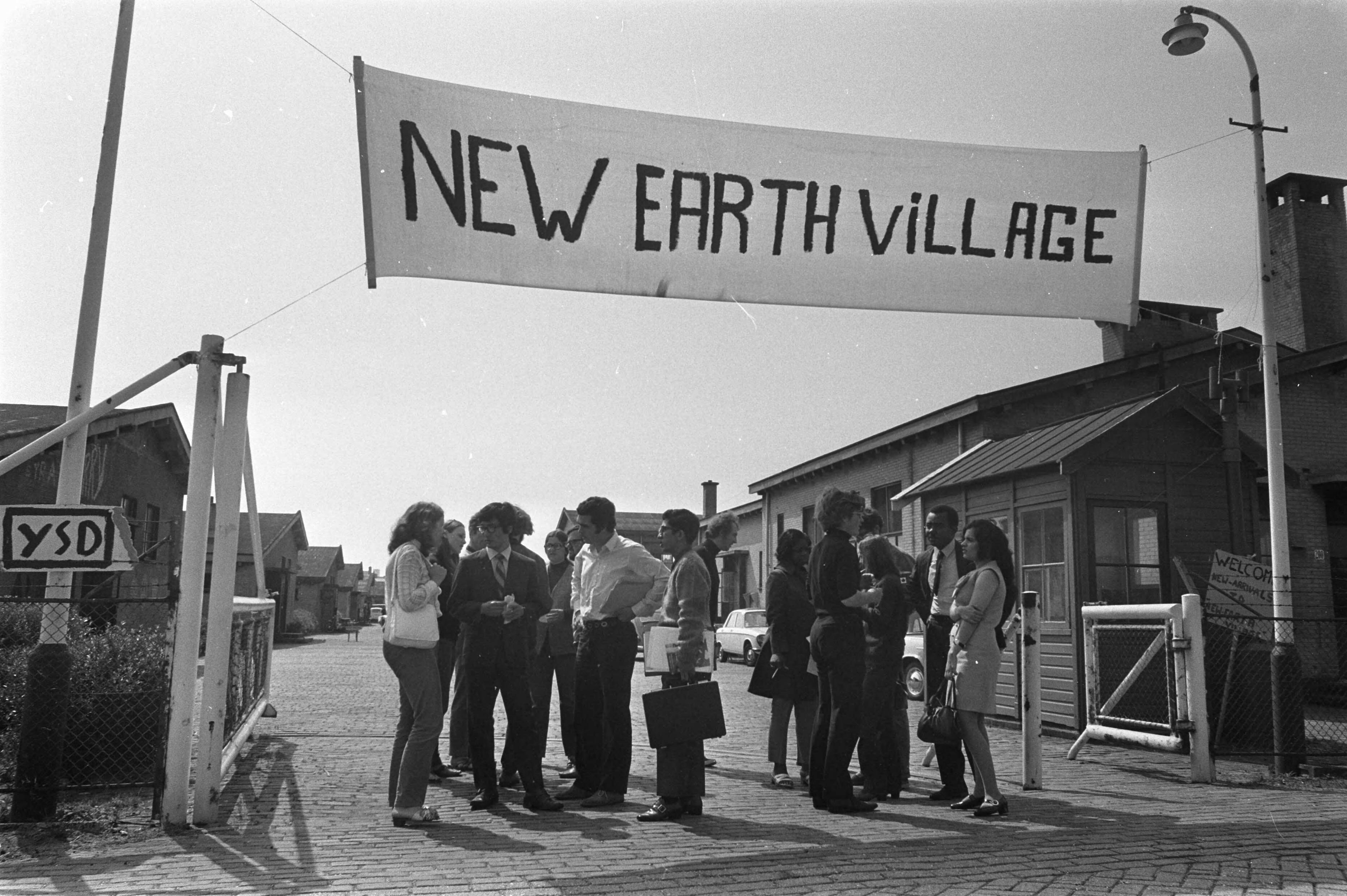 Fotocollectie Anefo — Internationaal Jeugdcongres ter voorbereiding i.v.m. FAO 2e Wereld Voedselcongres , in The New Earth , Den Haag jongeren in poort The new Earth praten / — Foto: Verhoeff, Bert / Anefo. Licentie: Set B: Rechtenvrij / Publiek Domein. Bron: Nationaal Archief. http://hdl.handle.net/10648/ab9981fe-d0b4-102d-bcf8-003048976d84