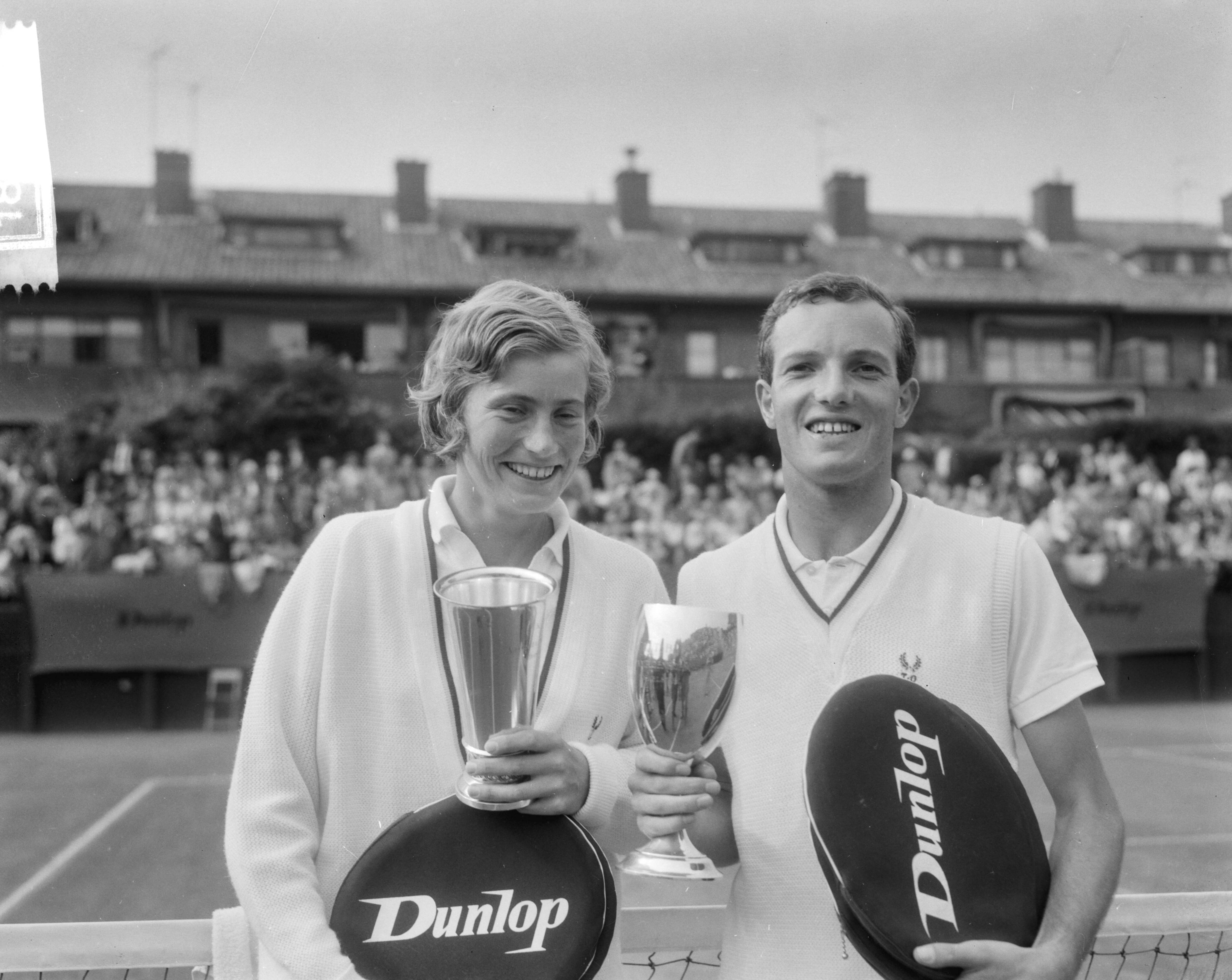 Fotocollectie Anefo — Nederlandse tenniskampioenschappen op de METS-banen te Scheveningen, Tom Okker en Trudy Groenman, winnaars van het enkelspel, met hun bekers — Foto: Bilsen, Joop van / Anefo. Licentie: Set B: Rechtenvrij / Publiek Domein. Bron: Nationaal Archief. http://hdl.handle.net/10648/aabb3dc2-d0b4-102d-bcf8-003048976d84