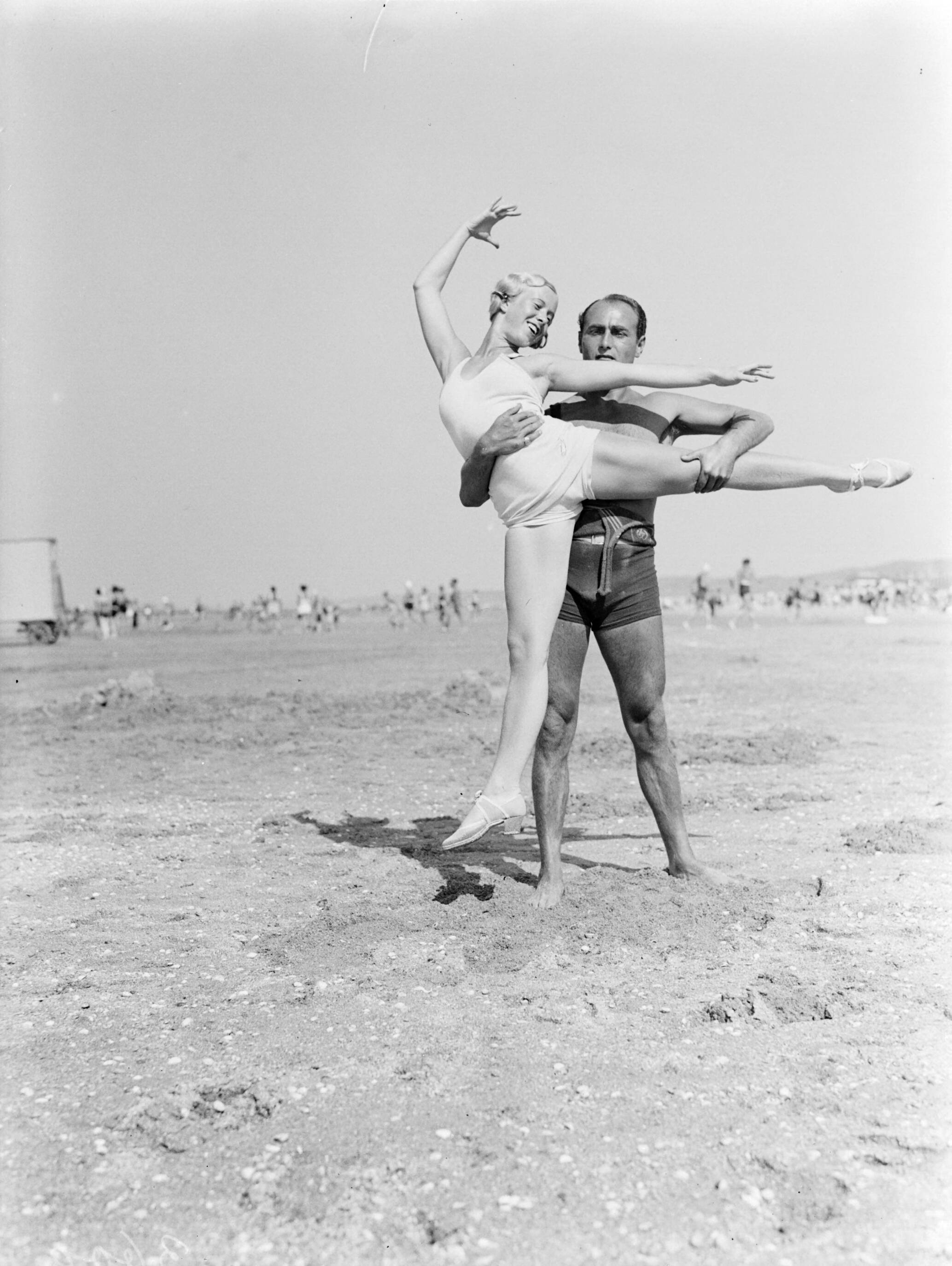 Scheveningen. — Een man (Farrar?) en een vrouw (Yvonne?) op het strand van Scheveningen — Foto: Poll, Willem van de. Licentie: Set B: Rechtenvrij / Publiek Domein. Bron: Nationaal Archief. http://hdl.handle.net/10648/ae9aae50-d0b4-102d-bcf8-003048976d84