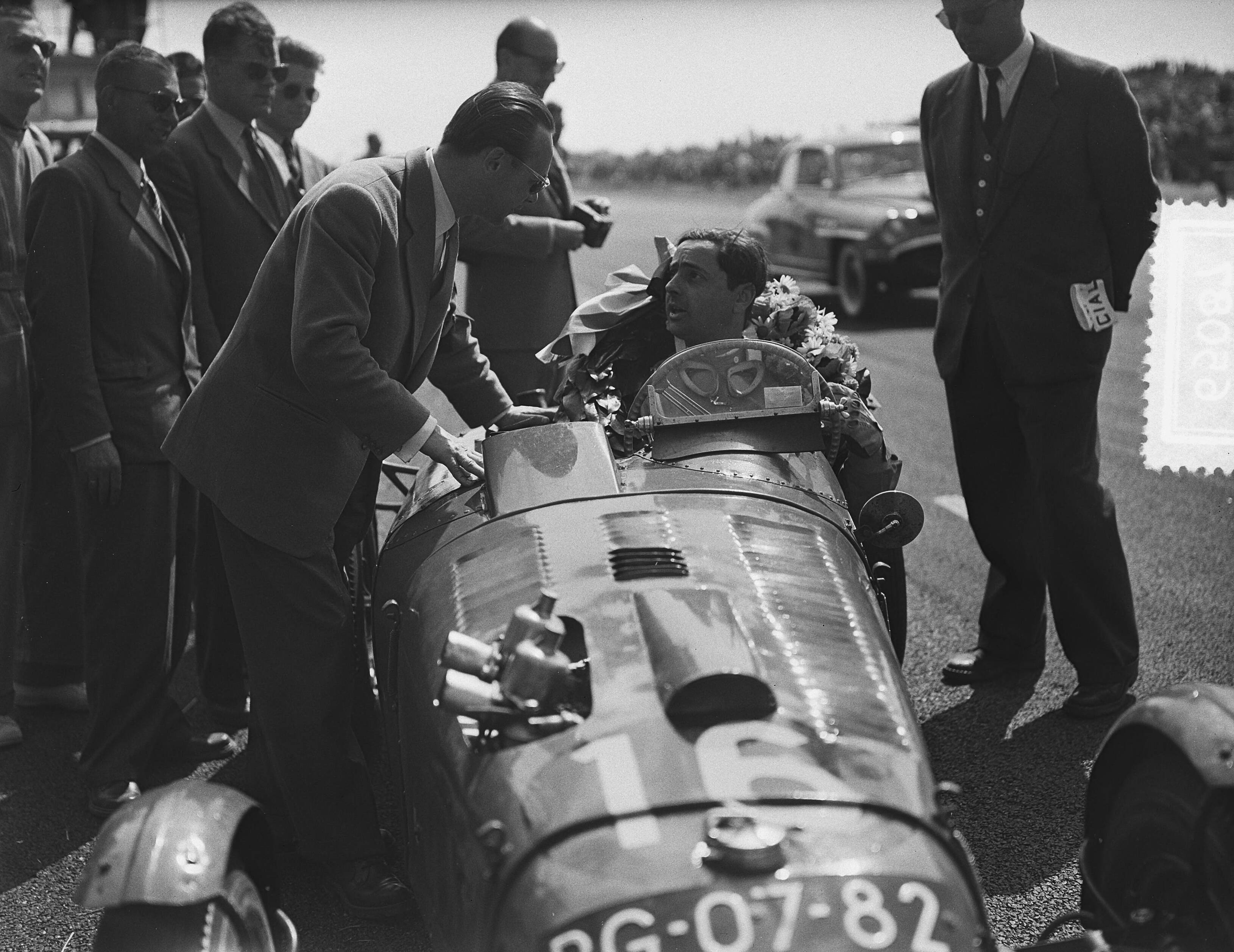 Fotocollectie Anefo — Nationale Sportwagenraces op het circuit van Zandvoort. Winnaar met krans — Foto: Bilsen, Joop van / Anefo. Licentie: Set B: Rechtenvrij / Publiek Domein. Bron: Nationaal Archief. http://hdl.handle.net/10648/a9234018-d0b4-102d-bcf8-003048976d84