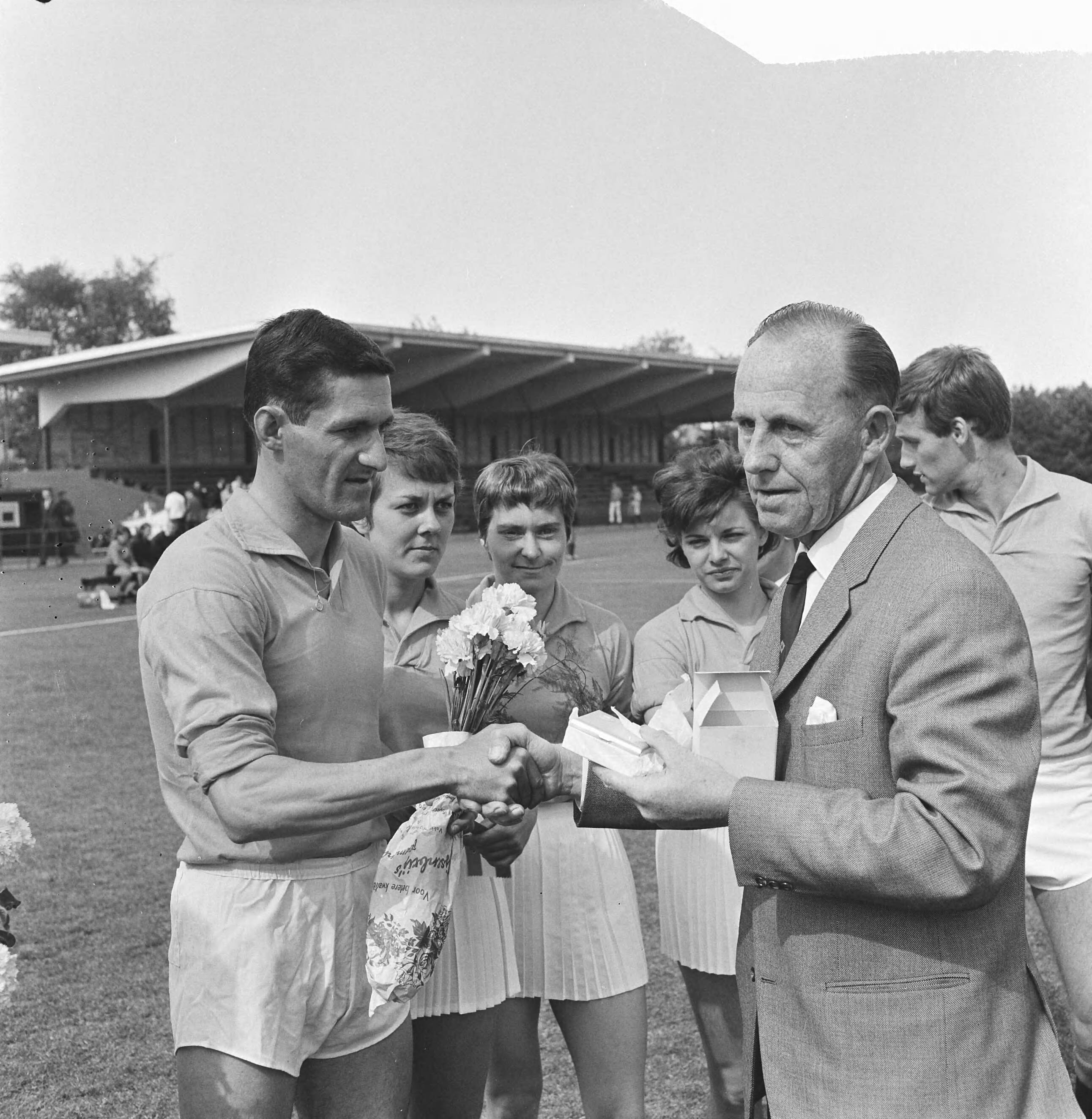 Fotocollectie Anefo — Korfbal. Nederland tegen België 8-2, Cees van Lunteren wordt gefeliciteerd door de voorzitter van de keuzecommissie met zijn 25e interland — Foto: Kroon, Ron / Anefo. Licentie: Set B: Rechtenvrij / Publiek Domein. Bron: Nationaal Archief. http://hdl.handle.net/10648/aaa9be8a-d0b4-102d-bcf8-003048976d84
