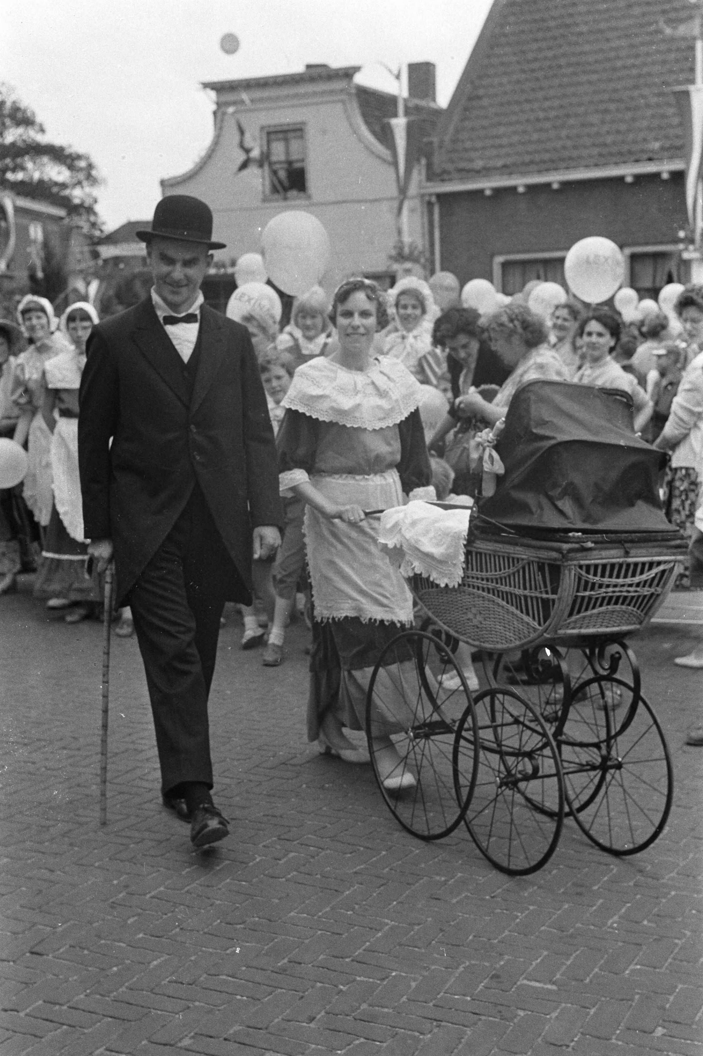 Fotocollectie Anefo — Feest in Zwammerdam t.g.v. 1000-jarig bestaan. De schoolmeester aan de wandel met zijn jongste spruit — Foto: Pot, Harry / Anefo. Licentie: Set B: Rechtenvrij / Publiek Domein. Bron: Nationaal Archief. http://hdl.handle.net/10648/a9b13de6-d0b4-102d-bcf8-003048976d84