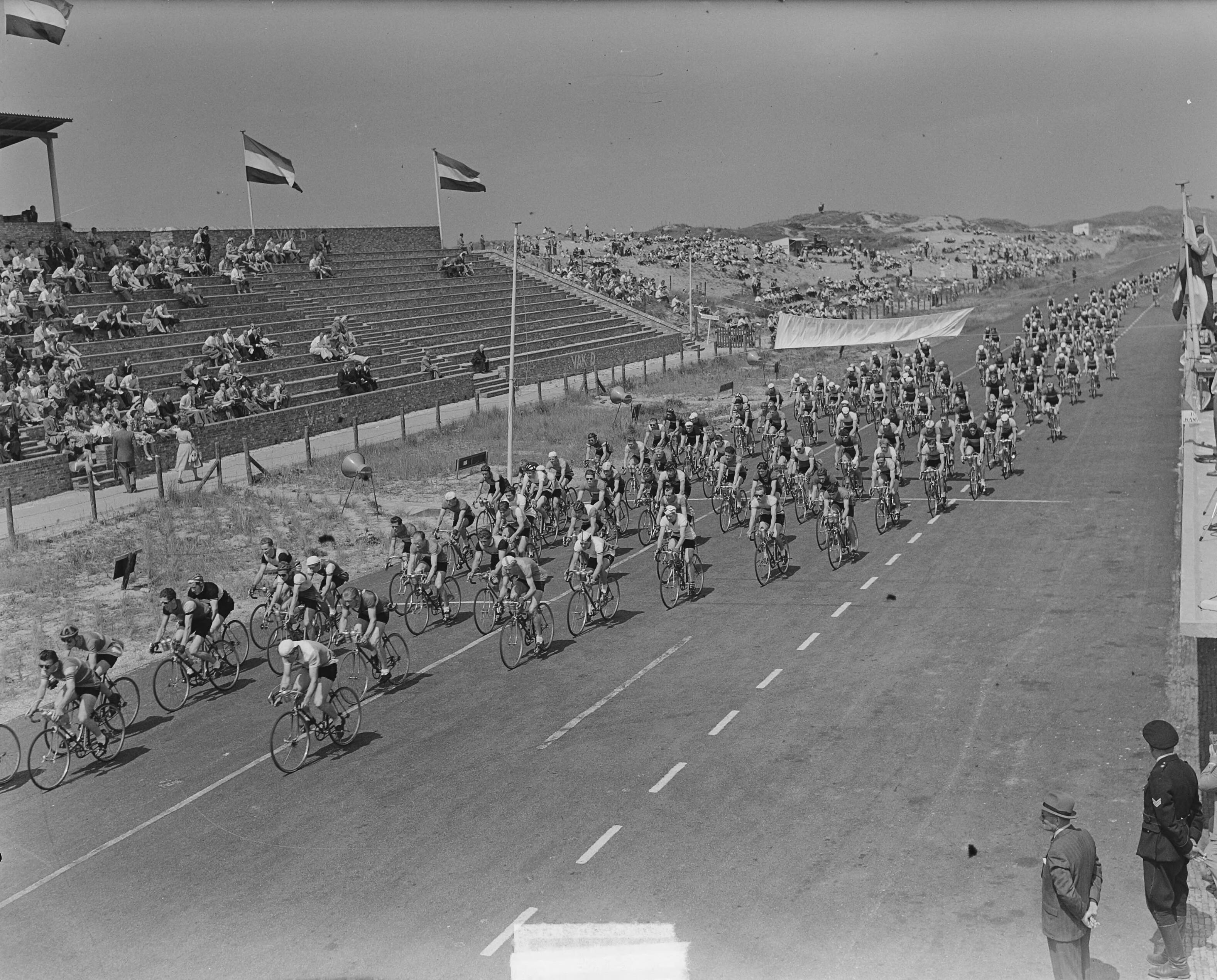Nederlands kampioenschap wielrennen voor amateurs 1951 — Nederlands kampioenschap wielrennen voor amateurs op het circuit van Zandvoort. Massastart — Foto: Noske, J.D. / Anefo. Licentie: Set B: Rechtenvrij / Publiek Domein. Bron: Nationaal Archief. http://hdl.handle.net/10648/a8ecc7ea-d0b4-102d-bcf8-003048976d84
