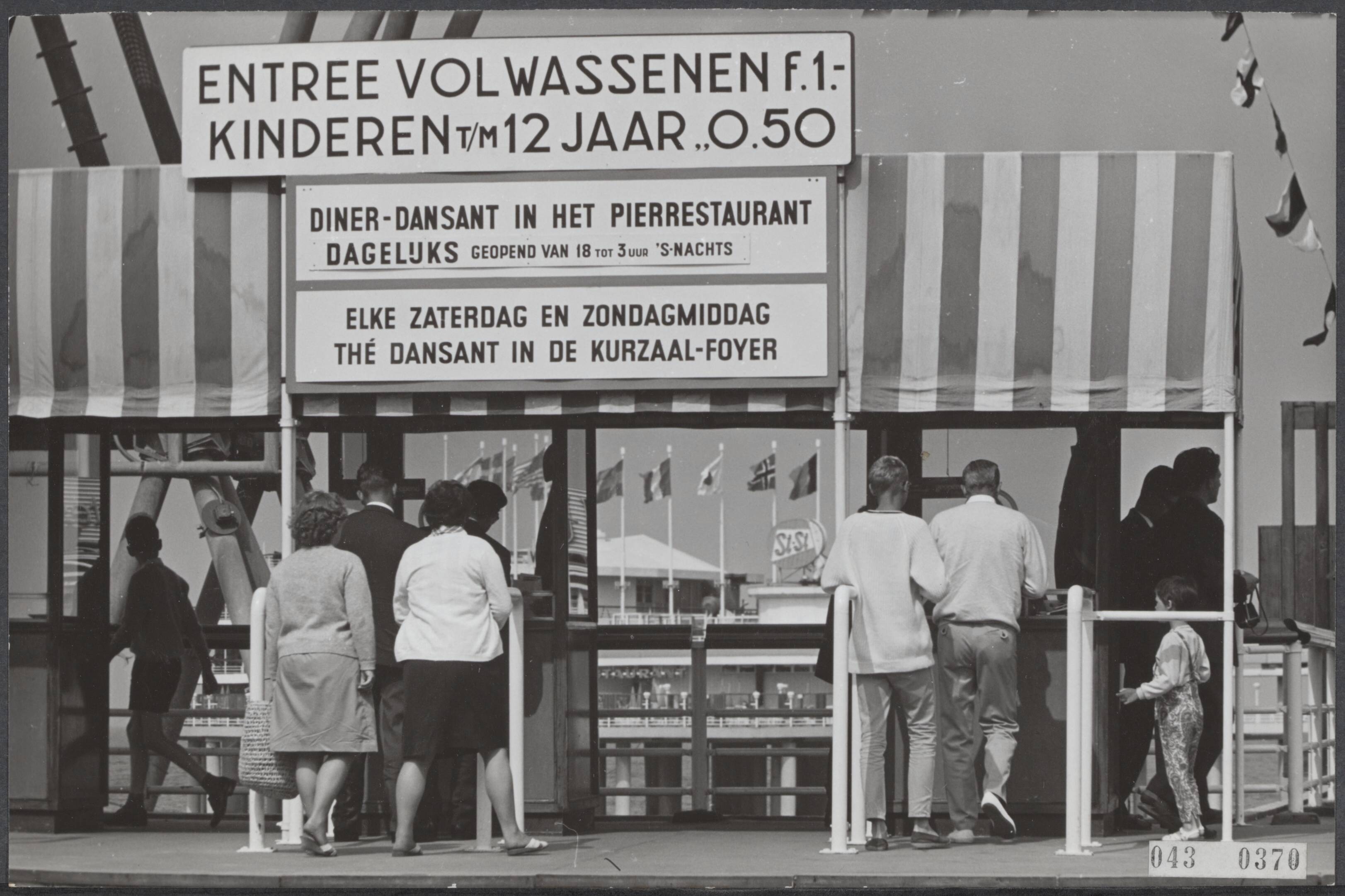 Fotocollectie Elsevier Binnenland — Minister Andriessen heeft beslist dat de toegangsprijs voor de Pier in Scheveningen drastisch verlaagd moet worden, nadat de prijs enkele dagen geleden opeens verdubbeld werd tot 1 gulden. De nieuwe prijs, 55 cent, gaat a.s. woensdag in. Vanmiddag hing het bord nog boven de kassa's met de "oude' prijs. Morgen moet het weg... — Foto: Koch, Eric / Anefo. Licentie: Set B: Rechtenvrij / Publiek Domein. Bron: Nationaal Archief. http://hdl.handle.net/10648/adf8ccfc-d0b4-102d-bcf8-003048976d84