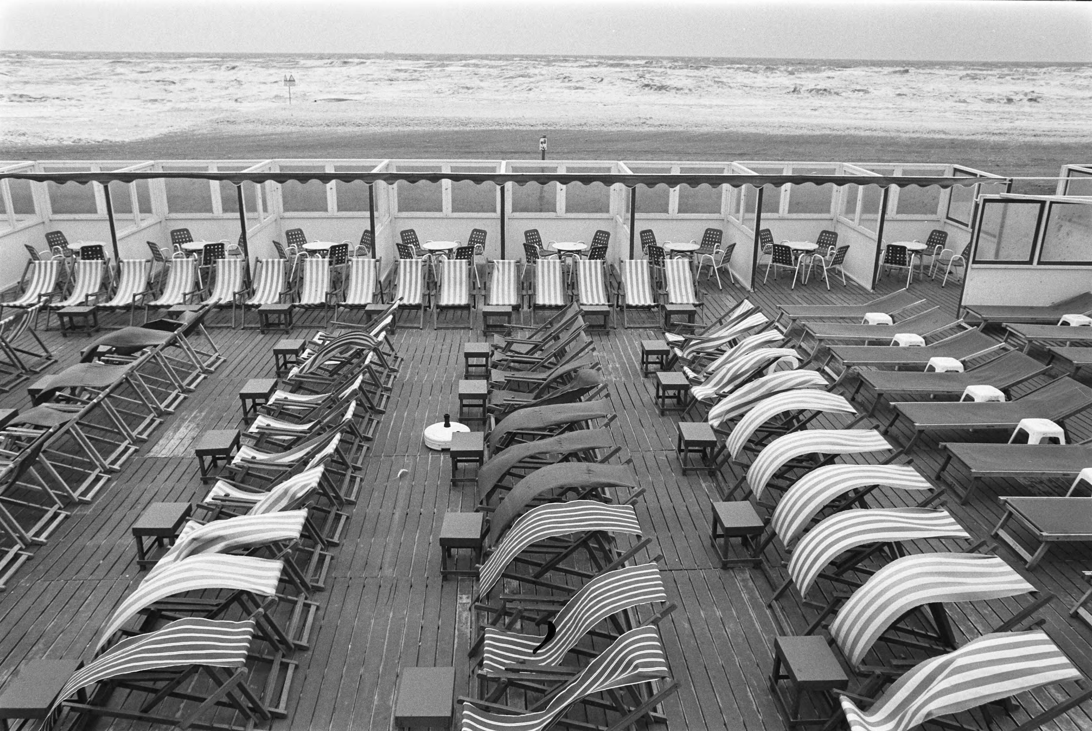 Strand in Scheveningen bedekt met een schuimlaag — Lege ligstoelen op het terras van een strandtent — Foto: Croes, Rob C. / Anefo. Licentie: Set B: Rechtenvrij / Publiek Domein. Bron: Nationaal Archief. http://hdl.handle.net/10648/ad29c934-d0b4-102d-bcf8-003048976d84