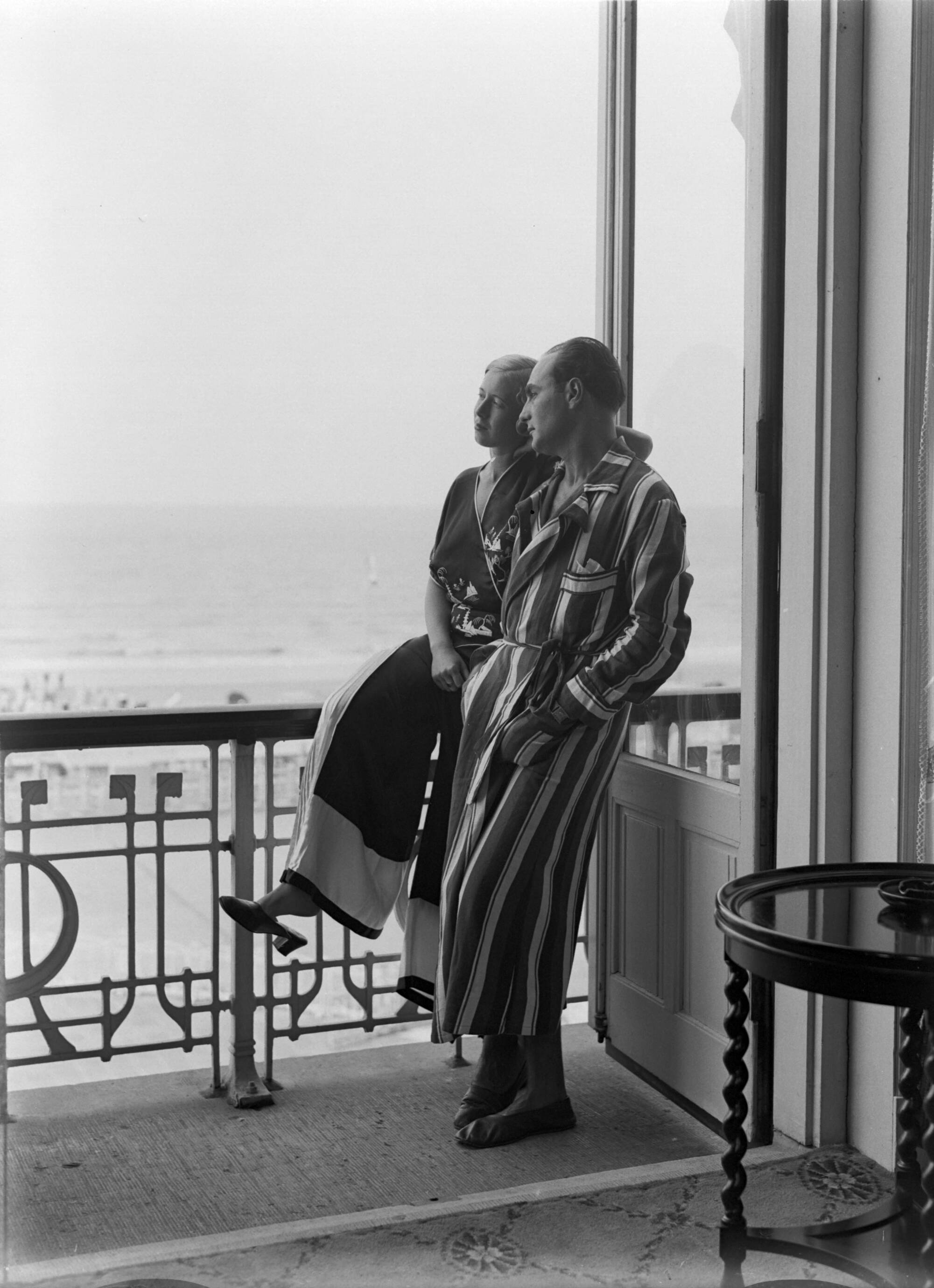 Scheveningen. — Een man (Farrar?) en een vrouw (Yvonne? bij het raam van een hotelkamer van het Palace Hotel in Scheveningen — Foto: Poll, Willem van de. Licentie: Set B: Rechtenvrij / Publiek Domein. Bron: Nationaal Archief. http://hdl.handle.net/10648/ae9ab54e-d0b4-102d-bcf8-003048976d84