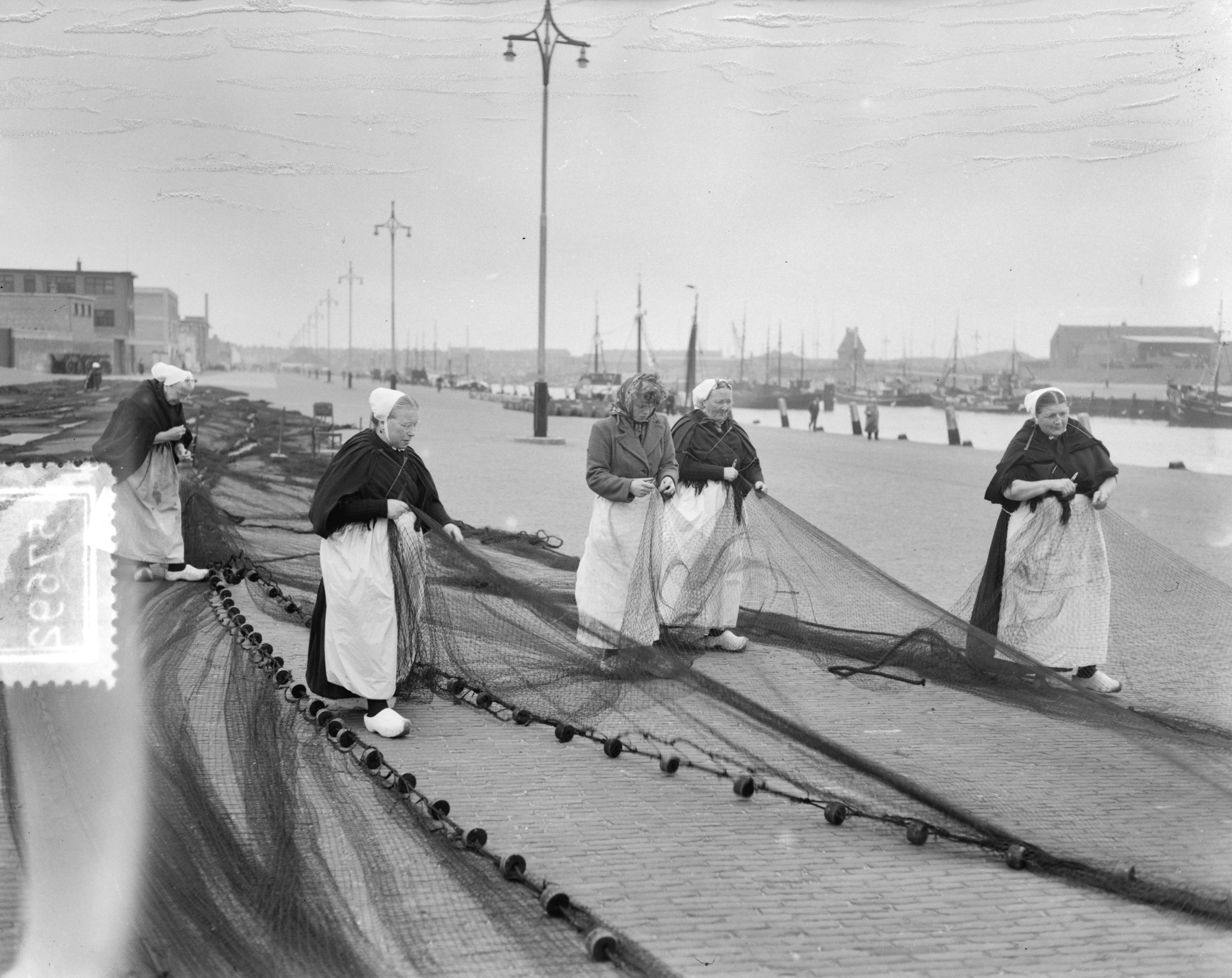 Fotocollectie Anefo — Scheveningse vrouwen aan het netten boeten — Foto: Duinen, G.W. van / Anefo. Licentie: Set B: Rechtenvrij / Publiek Domein. Bron: Nationaal Archief. http://hdl.handle.net/10648/a90d7620-d0b4-102d-bcf8-003048976d84