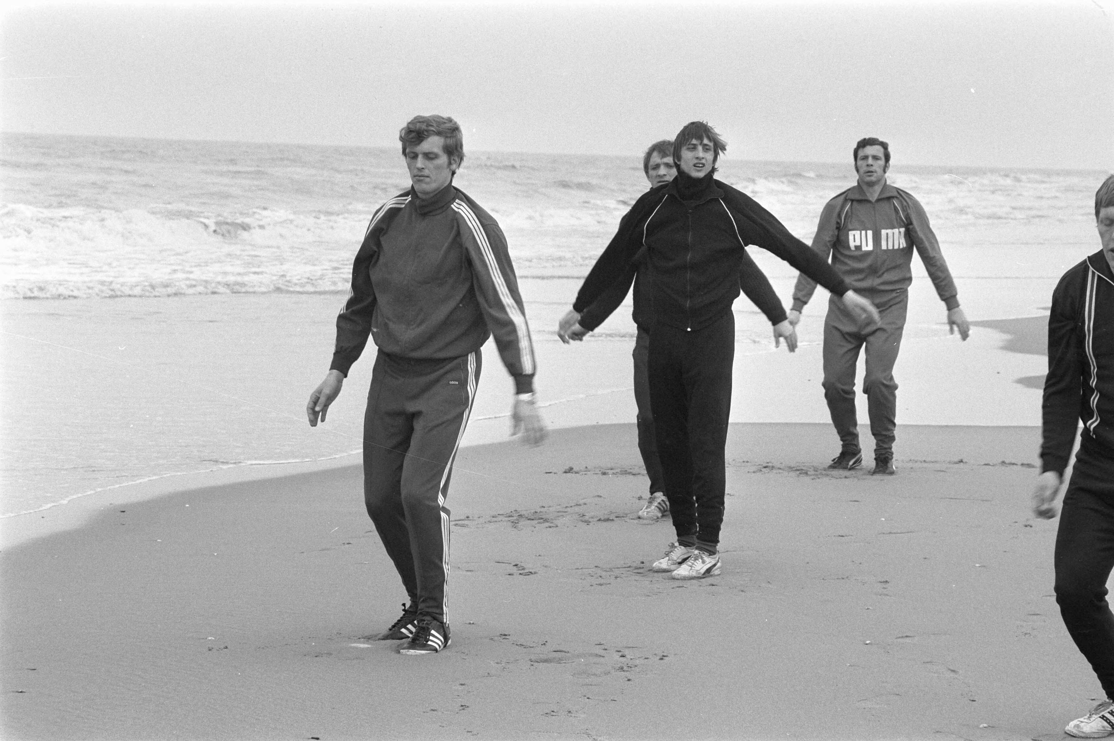 Training van Ajax in de duinen en op het strand bij Wassenaar ter voorbereiding voor de wedstrijd tegen Arsenal — Voetballers van Ajax trainen op het strand van Wassenaar. Piet Keizer, Johan Cruijff en Heinz Stuy. — Foto: Fotograaf Onbekend / Anefo. Licentie: Set B: Rechtenvrij / Publiek Domein. Bron: Nationaal Archief. http://hdl.handle.net/10648/ab940fe4-d0b4-102d-bcf8-003048976d84