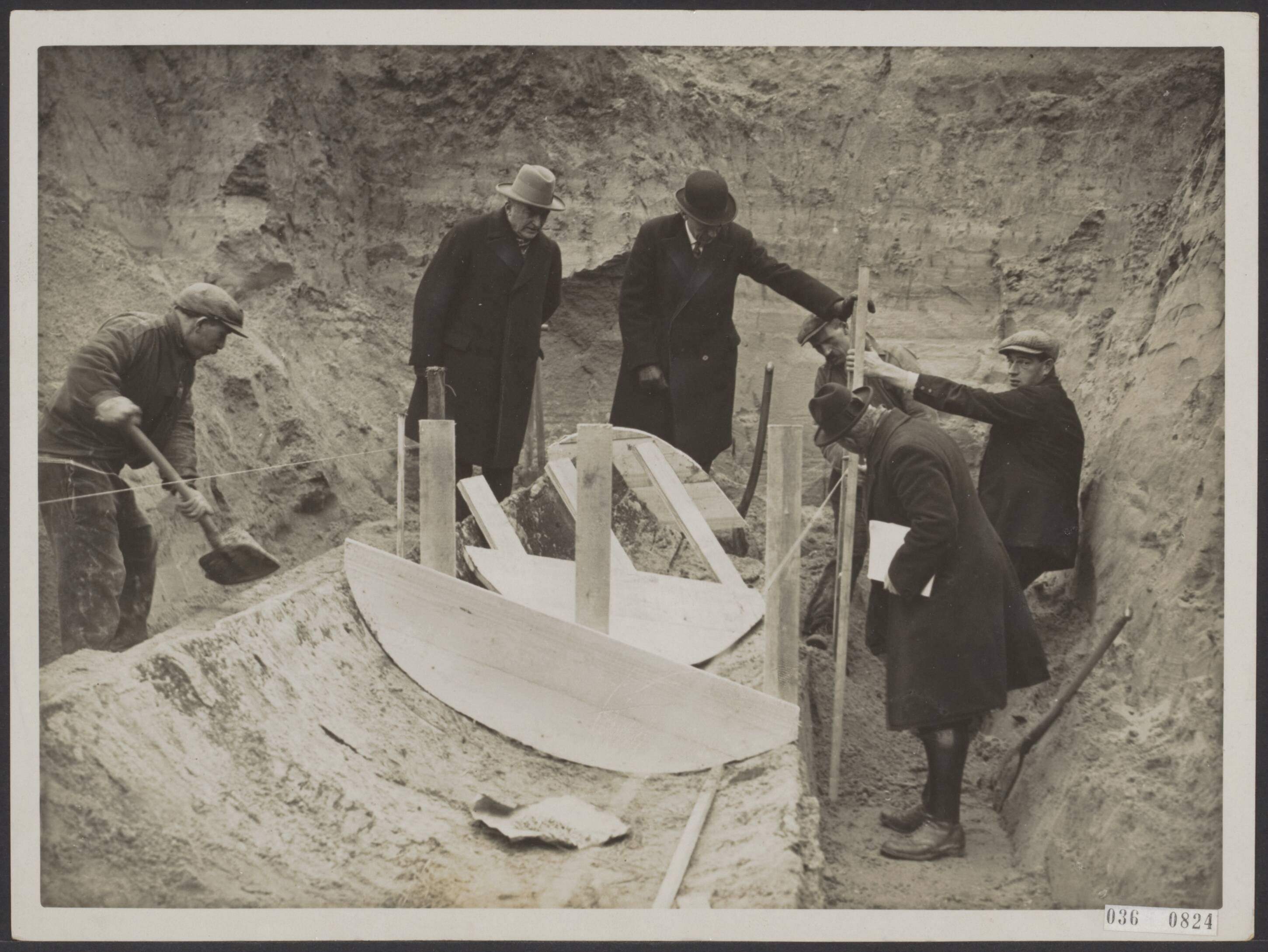 Fotocollectie Elsevier Binnenland — Het overschot van het schip hetgeen gevonden is aan de van Hoornekade in Utrecht en dateert van ongeveer 500 wordt met zorg versteekt om vervoerd te worden naar het Centraal Museum. Overzicht van de werkzaamheden. — Foto: N.V. Polygoon. Licentie: Set B: Rechtenvrij / Publiek Domein. Bron: Nationaal Archief. http://hdl.handle.net/10648/adecf5a8-d0b4-102d-bcf8-003048976d84