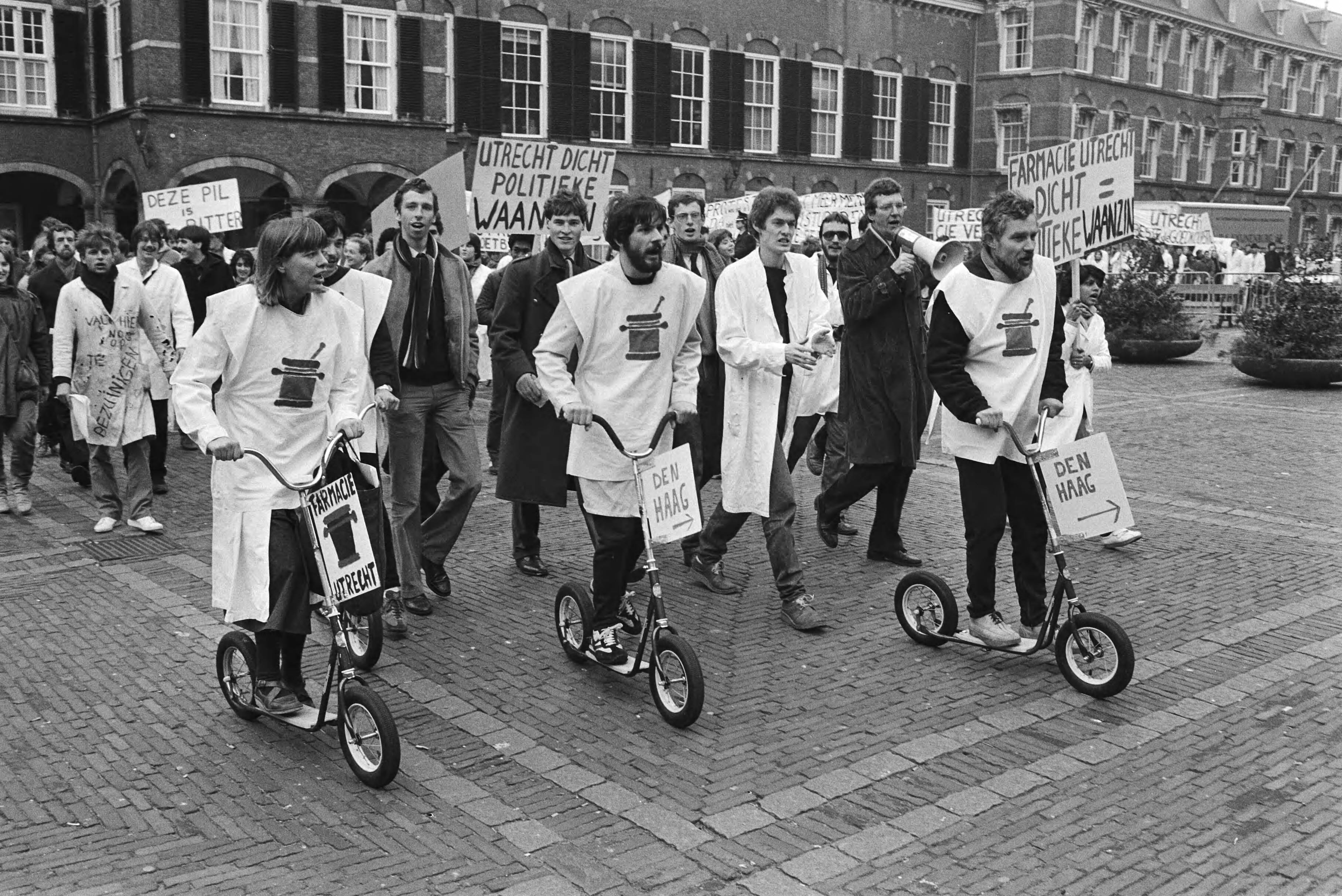 Studenten arriveren per step op het Binnenhof uit protest tegen de opheffing van de subfaculteit Farmacie in Utrecht — Den Haag|Zuid-Holland|betogingen |bezuinigingen |wetenschappelijk onderwijs |autopeds|Binnenhof — Foto: Antonisse, Marcel / Anefo. Licentie: Set B: Rechtenvrij / Publiek Domein. Bron: Nationaal Archief. http://hdl.handle.net/10648/ad267f0e-d0b4-102d-bcf8-003048976d84