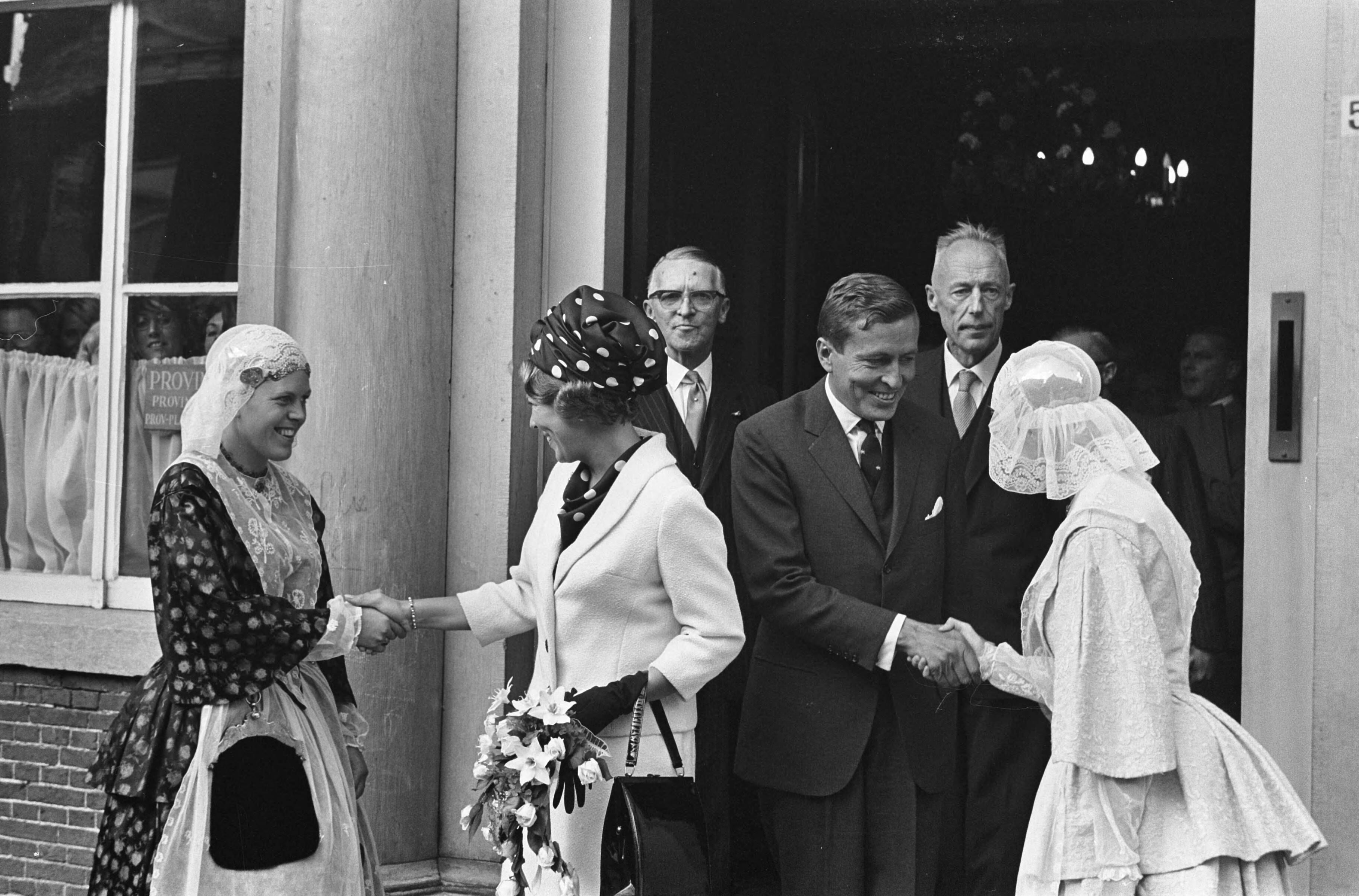 Bezoek van prinses Beatrix en Claus von Amsberg aan de drie noordelijke provincies — Bezoek prinses Beatrix en haar verloofde Claus von Amsberg aan Leeuwarden, het paar bij het Provinciehuis, het paar wordt voorgesteld aan twee meisjes in Friese klederdracht — Foto: Evers, Joost / Anefo. Licentie: Set B: Rechtenvrij / Publiek Domein. Bron: Nationaal Archief. http://hdl.handle.net/10648/aabef7a0-d0b4-102d-bcf8-003048976d84