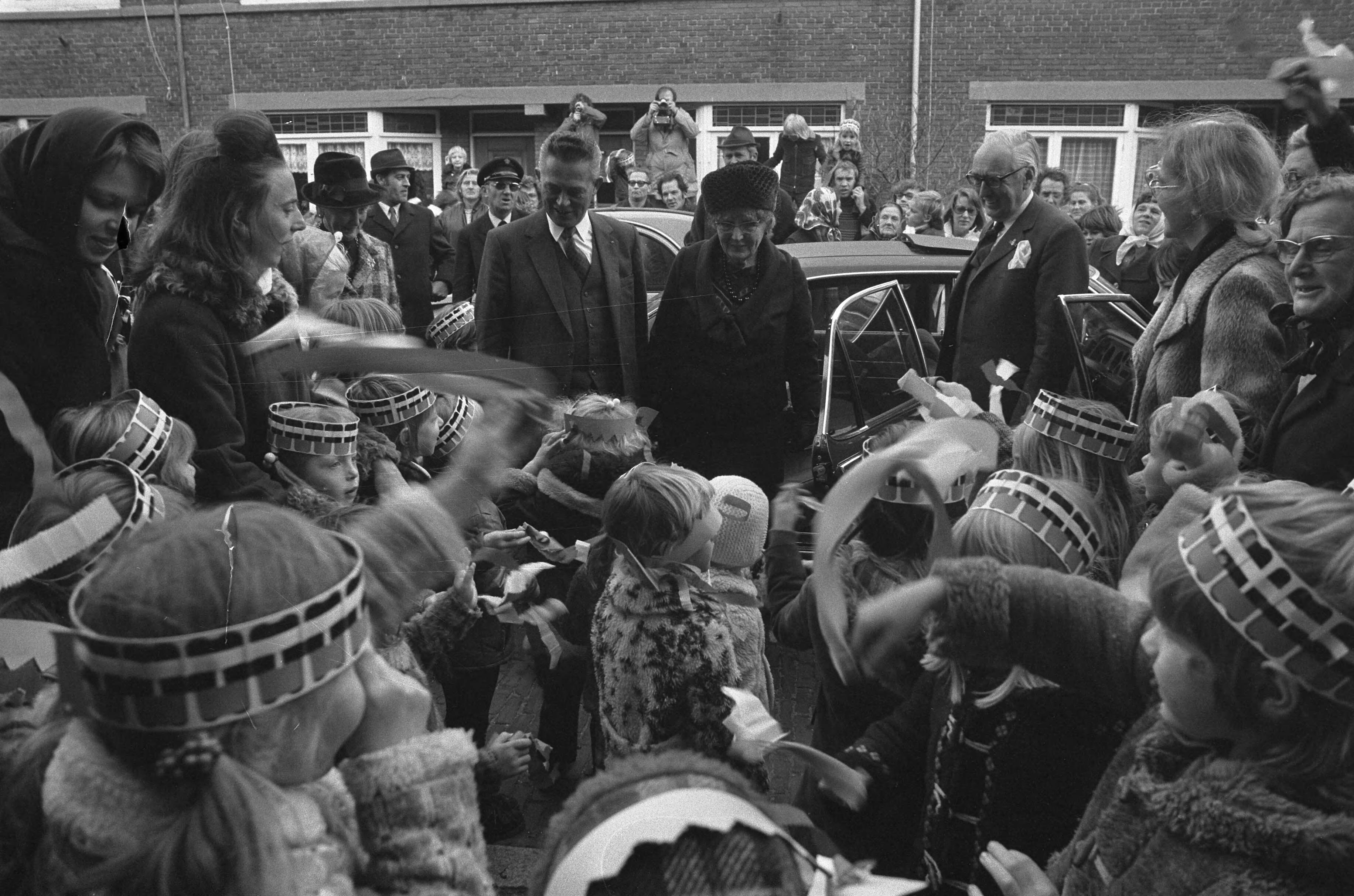 Koningin Juliana bezoekt scholen in Den Haag — De koningin bekijkt een aantal feestelijk uitgedoste kinderen van een door haar te openen peuterspeelzaal — Foto: Fotograaf Onbekend / Anefo. Licentie: Set B: Rechtenvrij / Publiek Domein. Bron: Nationaal Archief. http://hdl.handle.net/10648/ac3c3d9a-d0b4-102d-bcf8-003048976d84