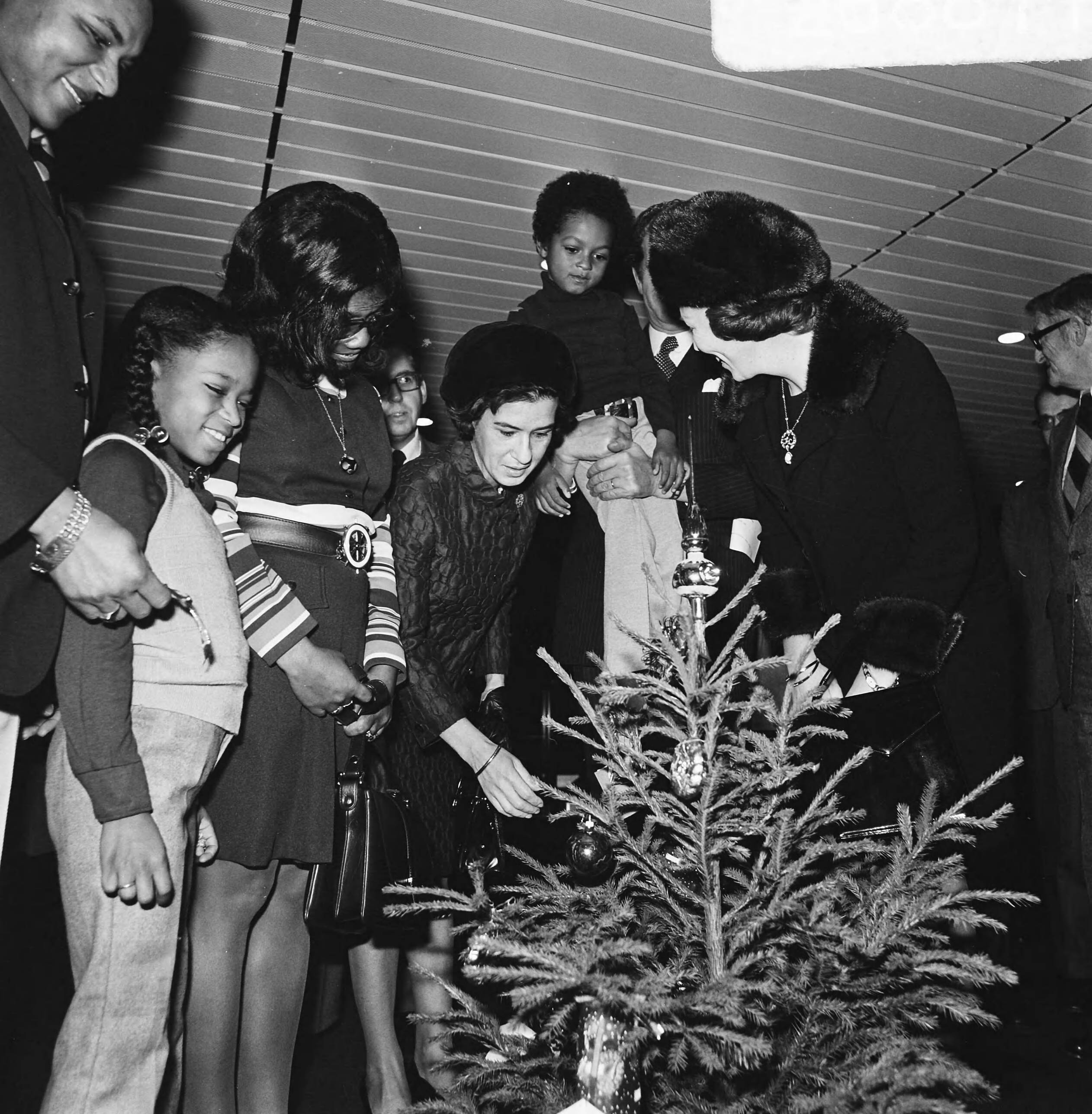 Prinses Beatrix overhandigt de sleutel van de dertigste burgerzinwoning in het stadhuis van Den Haag — De prinses met kinderen en genodigden bij een kerstboom — Foto: Mieremet, Rob / Anefo. Licentie: Set B: Rechtenvrij / Publiek Domein. Bron: Nationaal Archief. http://hdl.handle.net/10648/ac3ed988-d0b4-102d-bcf8-003048976d84