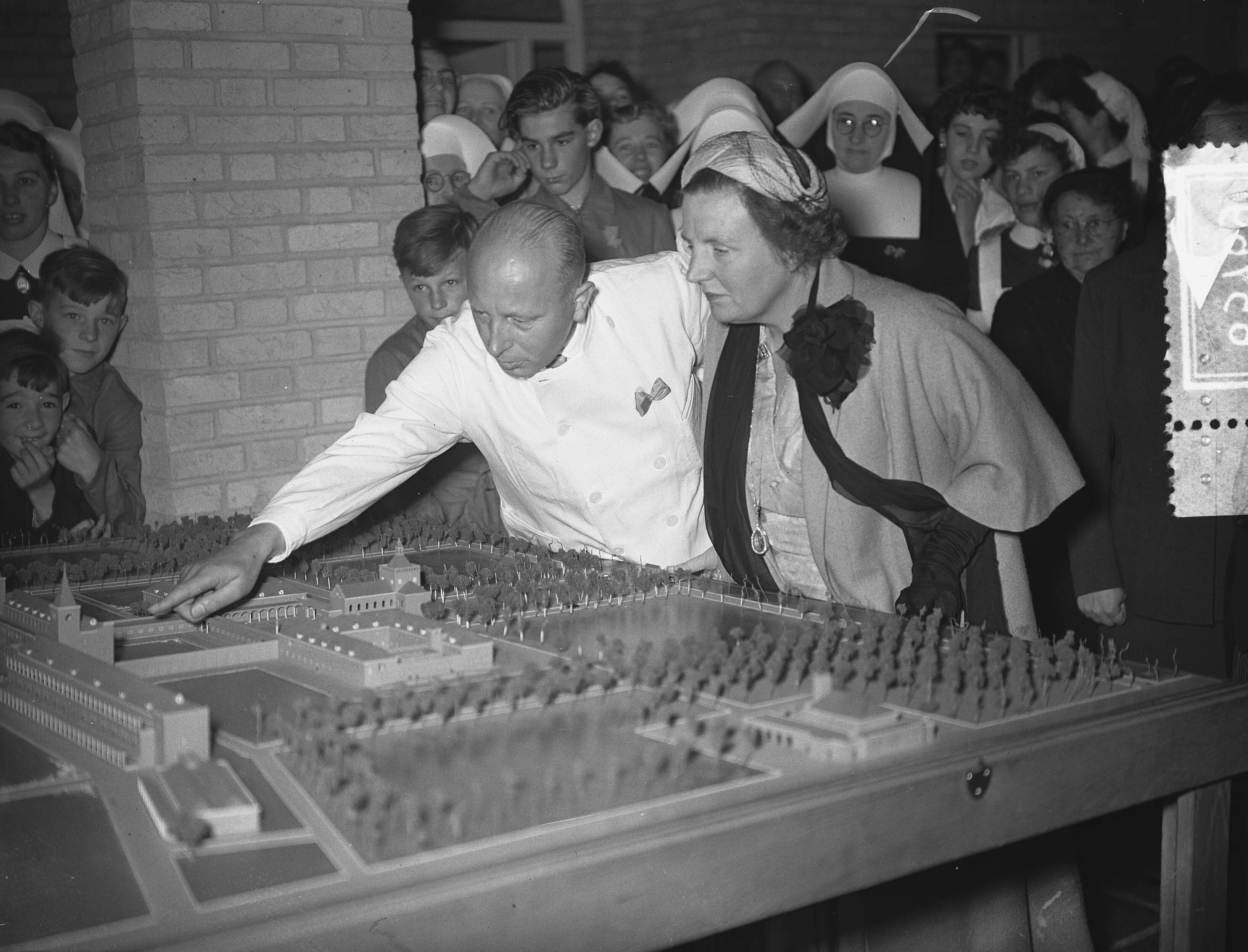 Koningin Juliana opent sanatorium De Klokkenberg in Breda — Opening van sanatorium "Klokkenberg". Koningin Juliana buigt zich over de maquette — Foto: Bilsen, Joop van / Anefo. Licentie: Set B: Rechtenvrij / Publiek Domein. Bron: Nationaal Archief. http://hdl.handle.net/10648/a9253d14-d0b4-102d-bcf8-003048976d84
