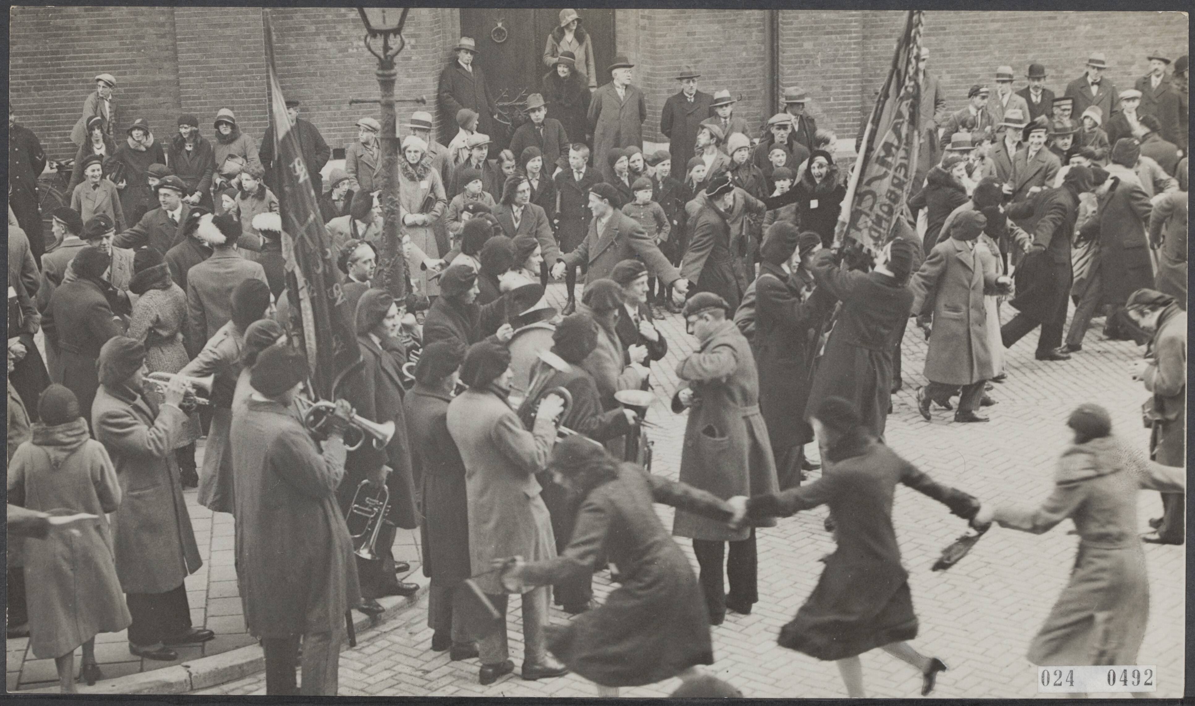 Fotocollectie Elsevier Binnenland — 16e Dietsch Studenten congraes. Een rondedans bij het studenten muziekkorps op het plein voor de universiteit — Foto: N.V. Polygoon. Licentie: Set B: Rechtenvrij / Publiek Domein. Bron: Nationaal Archief. http://hdl.handle.net/10648/add7a2f2-d0b4-102d-bcf8-003048976d84