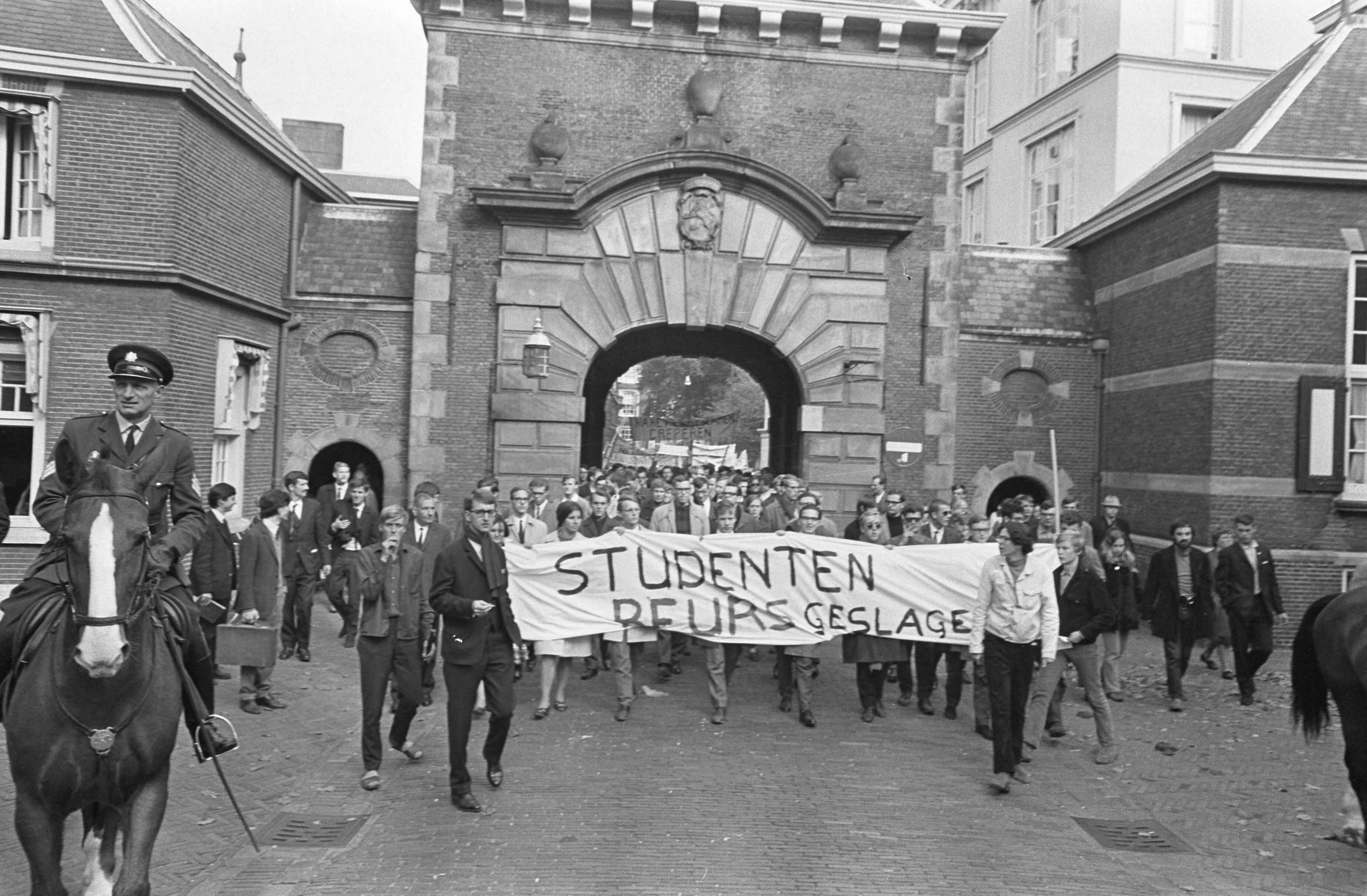 Studentendemonstratie inzake studietoelage, optocht van Amsterdam naar Den Haag — Studenten arriveren met spandoeken op het Haagse Binnenhof — Foto: Fotograaf Onbekend / Anefo. Licentie: Set B: Rechtenvrij / Publiek Domein. Bron: Nationaal Archief. http://hdl.handle.net/10648/aafe5f3a-d0b4-102d-bcf8-003048976d84