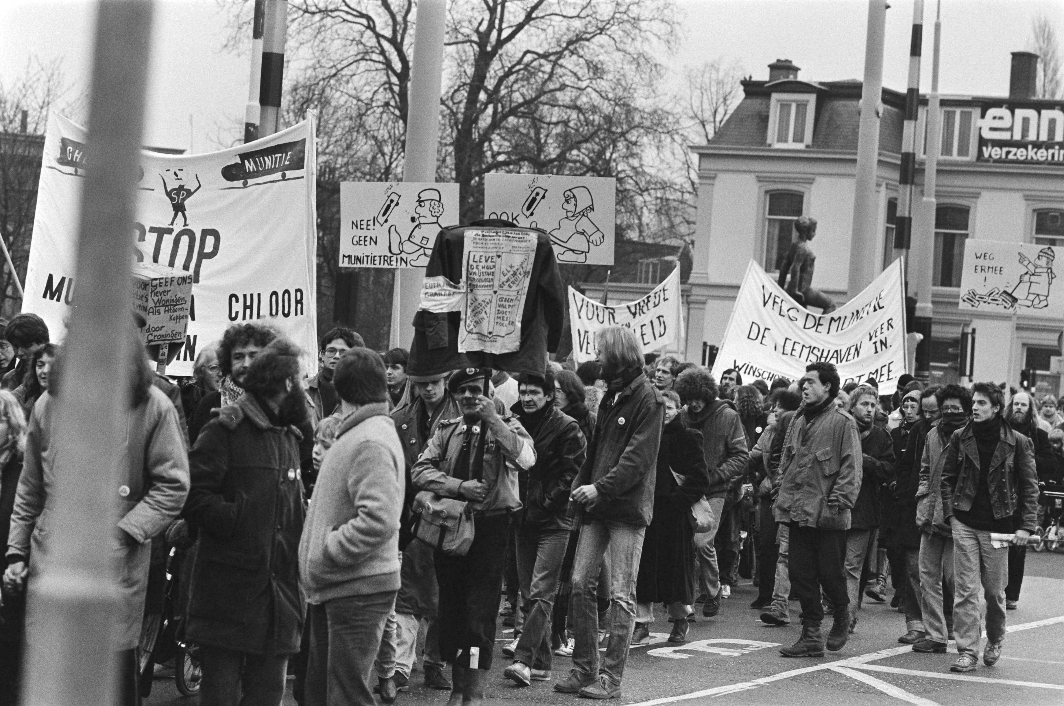 Fotocollectie Anefo — Dem. in Groningen tegen munitietransporten met treinen van de Eemshaven naar West-Duitsland. Dem. met diverse spandoeken — Foto: Bogaerts, Rob / Anefo. Licentie: Set B: Rechtenvrij / Publiek Domein. Bron: Nationaal Archief. http://hdl.handle.net/10648/ad0dfaec-d0b4-102d-bcf8-003048976d84