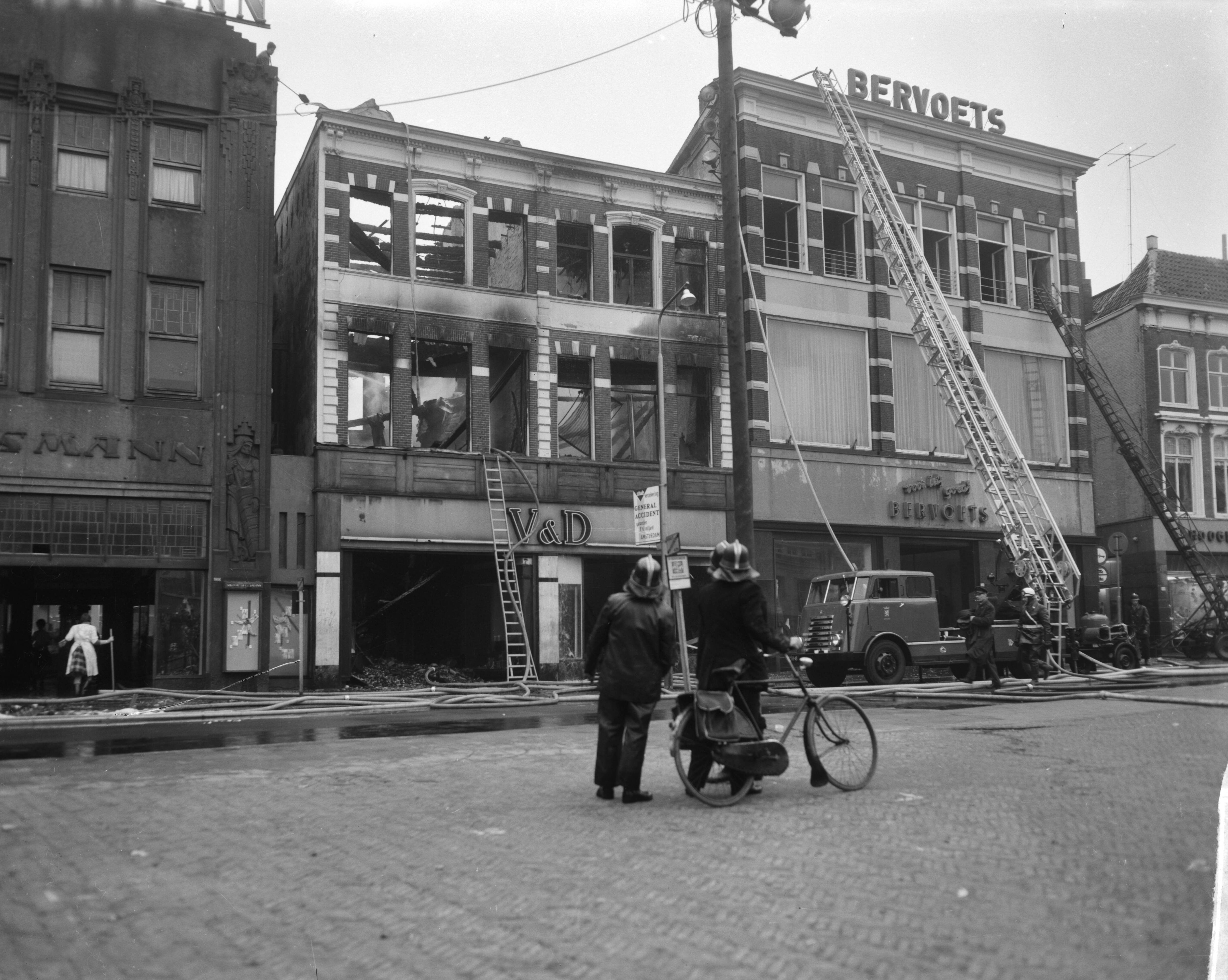 Fotocollectie Anefo — Brand bij V&D te Leeuwarden. Onbeschadigde confectie wordt in veiligheid gebracht — Foto: Bilsen, Joop van / Anefo. Licentie: Set B: Rechtenvrij / Publiek Domein. Bron: Nationaal Archief. http://hdl.handle.net/10648/aa2ed440-d0b4-102d-bcf8-003048976d84