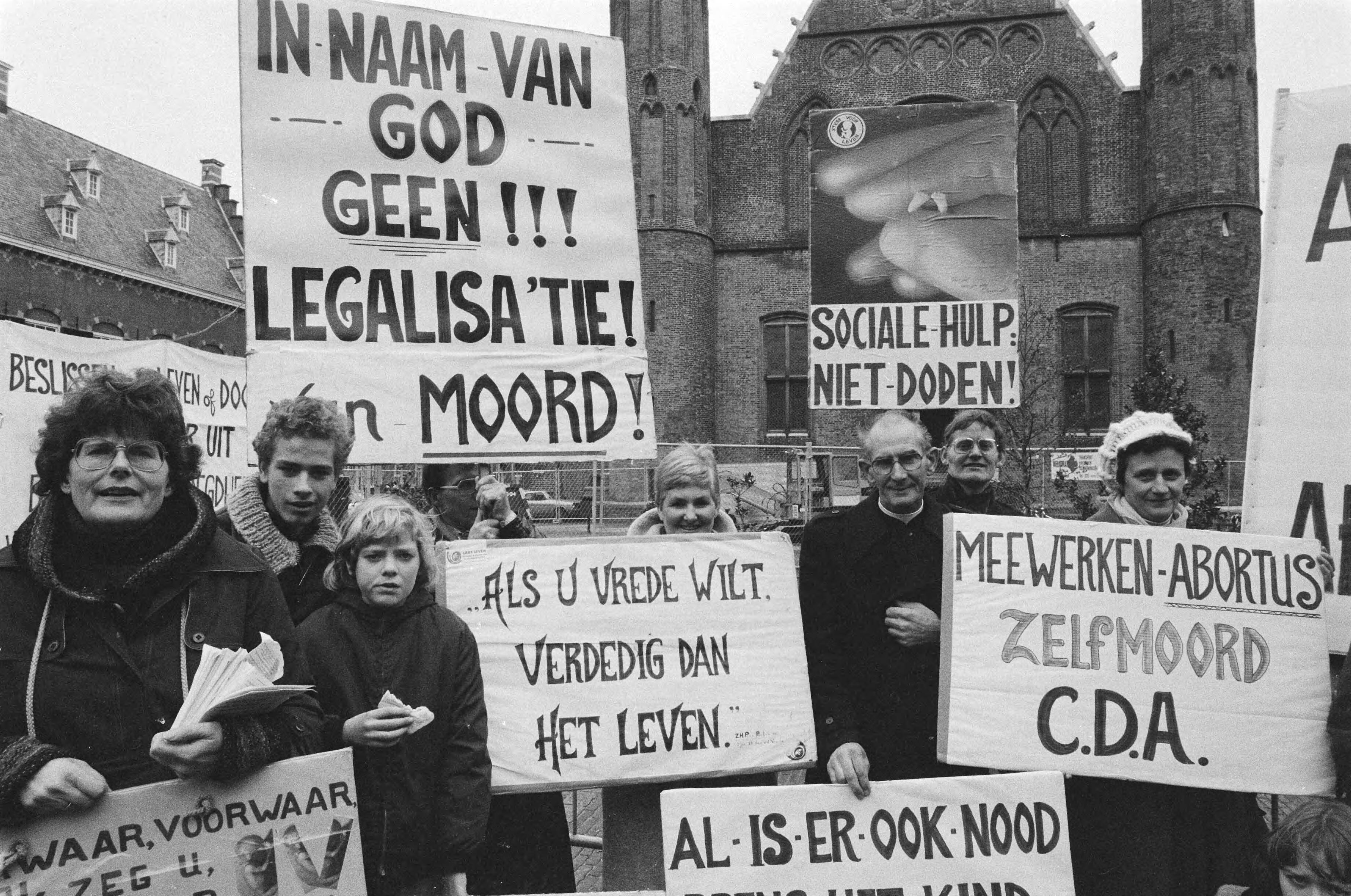 Fotocollectie Anefo — Demonstratie van tegenstanders van abortus op Binnenhof, Den Haag , demonstranten met in midden Pater Koopman — Foto: Dijk, Hans van / Anefo. Licentie: Set B: Rechtenvrij / Publiek Domein. Bron: Nationaal Archief. http://hdl.handle.net/10648/aced93f6-d0b4-102d-bcf8-003048976d84