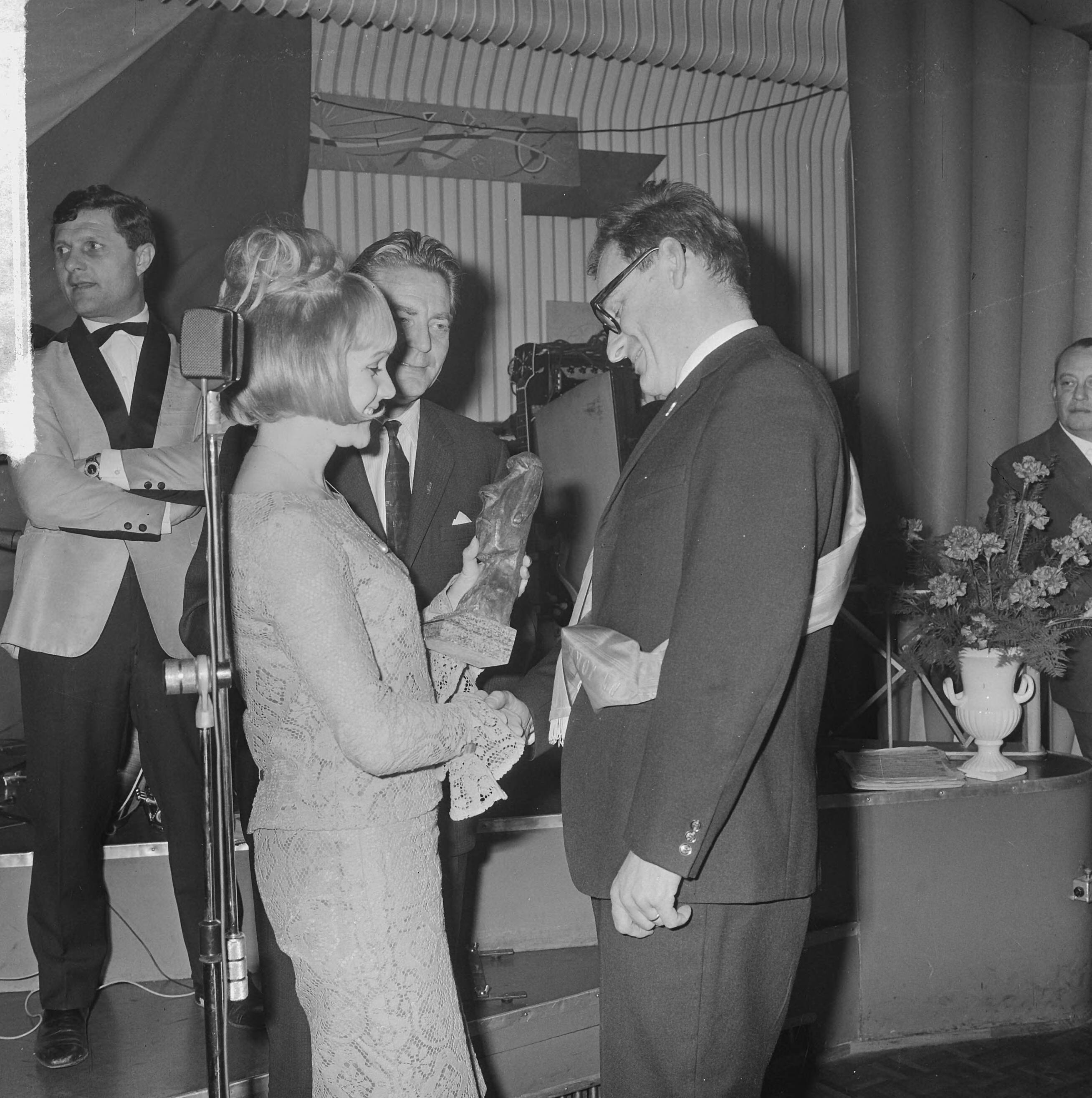 Fotocollectie Anefo — Uitreiking Prix de Joke 1965 aan Wijnand J. Maat in Hotel Bouwes te Zandvoort. Miss Zandvoort (Anneke Geerts) overhandigde de prijs, in het midden Bert Haanstra, de winnaar van vorig jaar — Foto: Koch, Eric / Anefo. Licentie: Set B: Rechtenvrij / Publiek Domein. Bron: Nationaal Archief. http://hdl.handle.net/10648/aa9ce78c-d0b4-102d-bcf8-003048976d84