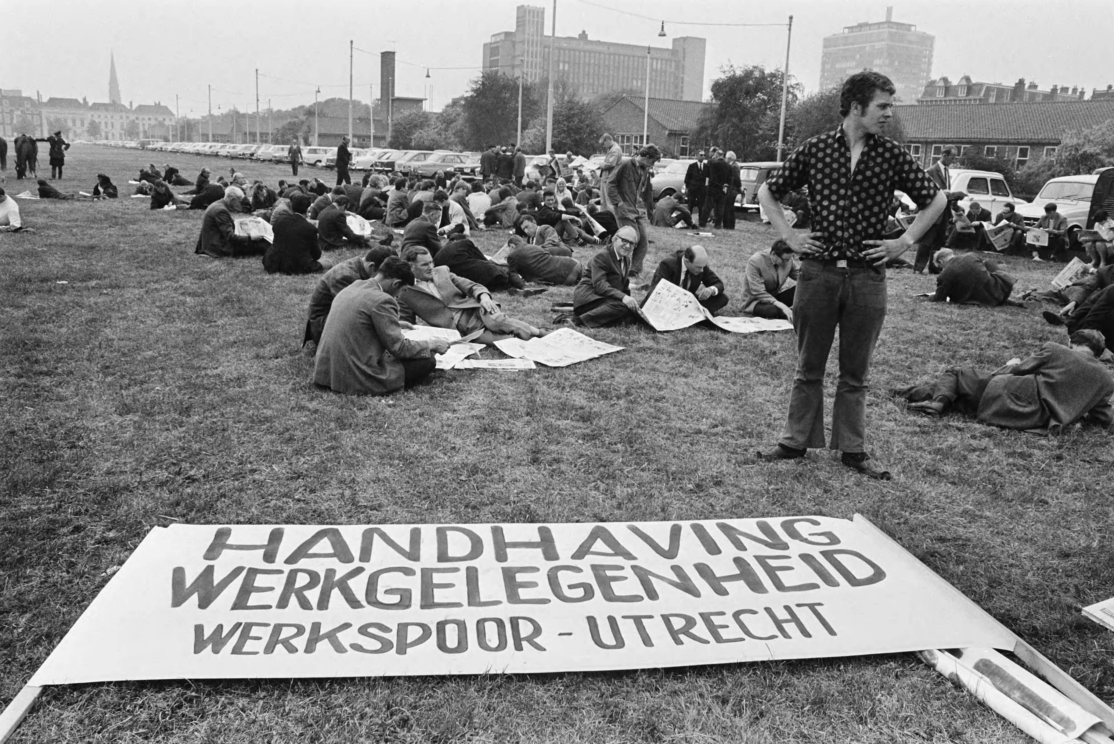 Fotocollectie Anefo — Arbeiders staken bij Werkspoor-Utrecht i.v.m. moeilijke positie van het bedrijf; werkspoorarbeiders op Malieveld, Den Haag , met bord — Foto: Evers, Joost / Anefo. Licentie: Set B: Rechtenvrij / Publiek Domein. Bron: Nationaal Archief. http://hdl.handle.net/10648/ab9843c0-d0b4-102d-bcf8-003048976d84