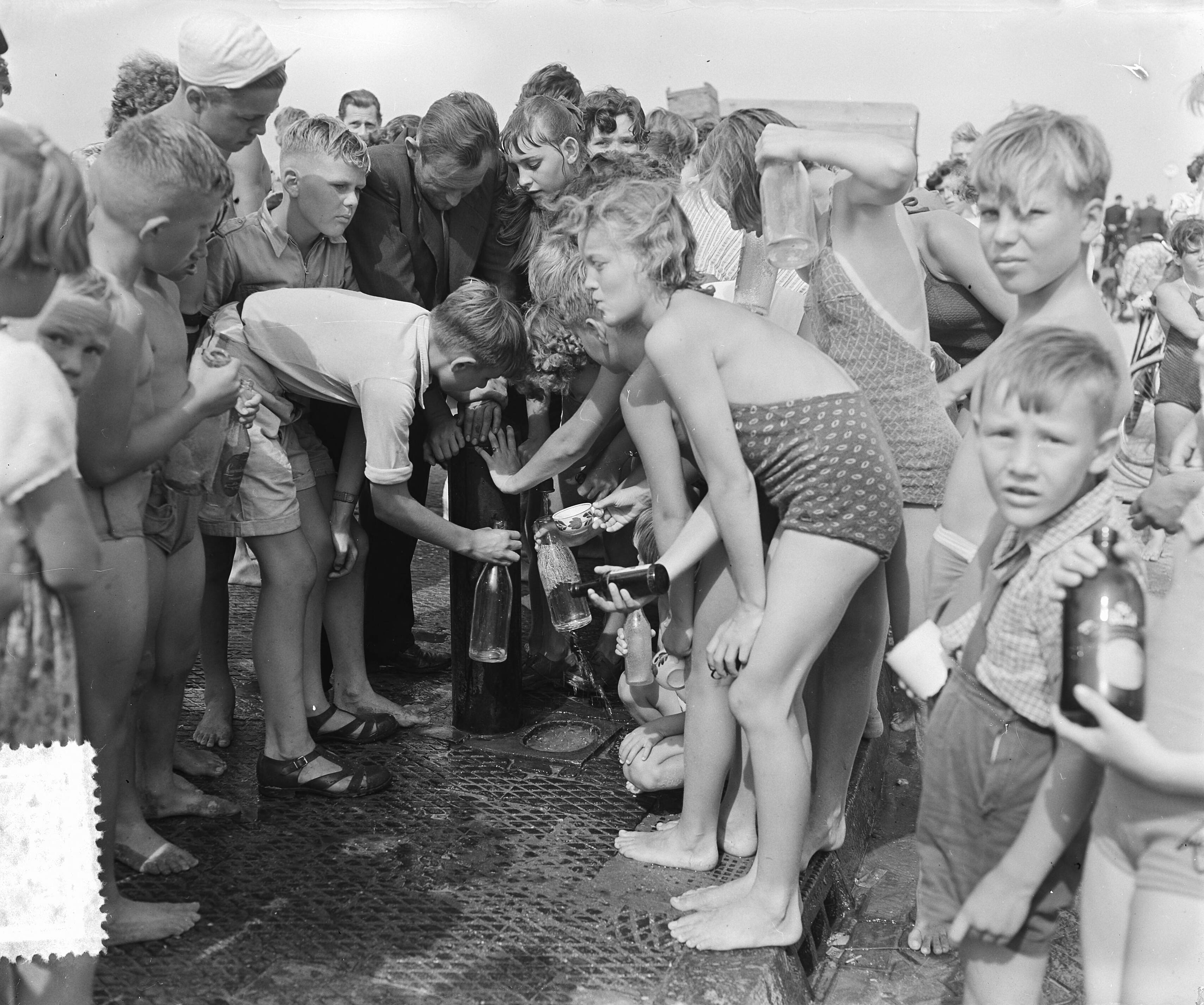 Fotocollectie Anefo — Hete dag aan het strand van Scheveningen. Drukte bij de waterpomp — Foto: Duinen, H. van / Anefo. Licentie: Set B: Rechtenvrij / Publiek Domein. Bron: Nationaal Archief. http://hdl.handle.net/10648/a910e454-d0b4-102d-bcf8-003048976d84