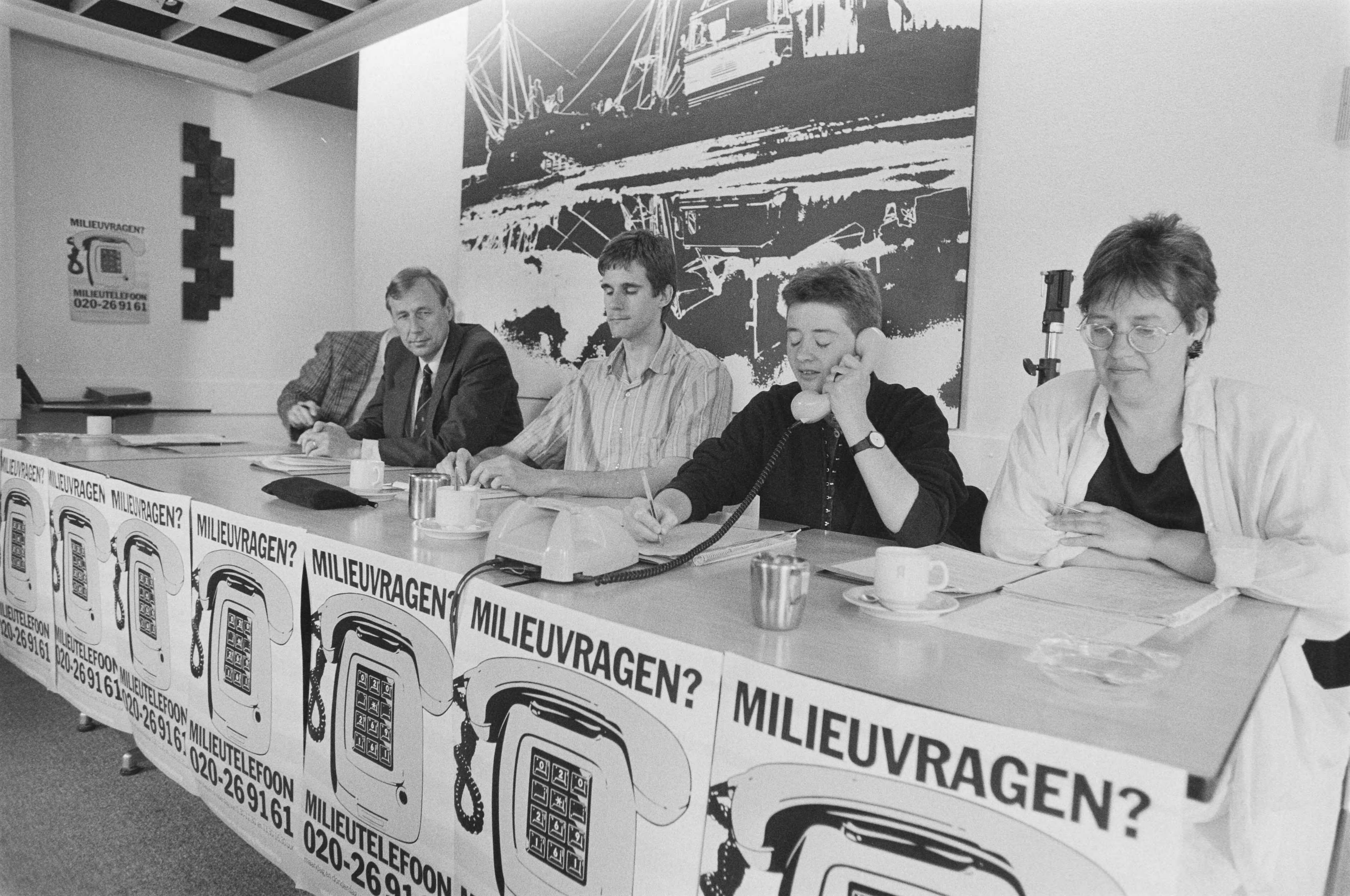 Fotocollectie Anefo — Milieutelefoon van Vereniging Milieudefensie geopend in Den Haag ; minister Nijpels stelt eerste vraag aan medewerkster Saskia Ozinga , links directeur — Foto: Bogaerts, Rob / Anefo. Licentie: Set B: Rechtenvrij / Publiek Domein. Bron: Nationaal Archief. http://hdl.handle.net/10648/ad60b9c6-d0b4-102d-bcf8-003048976d84