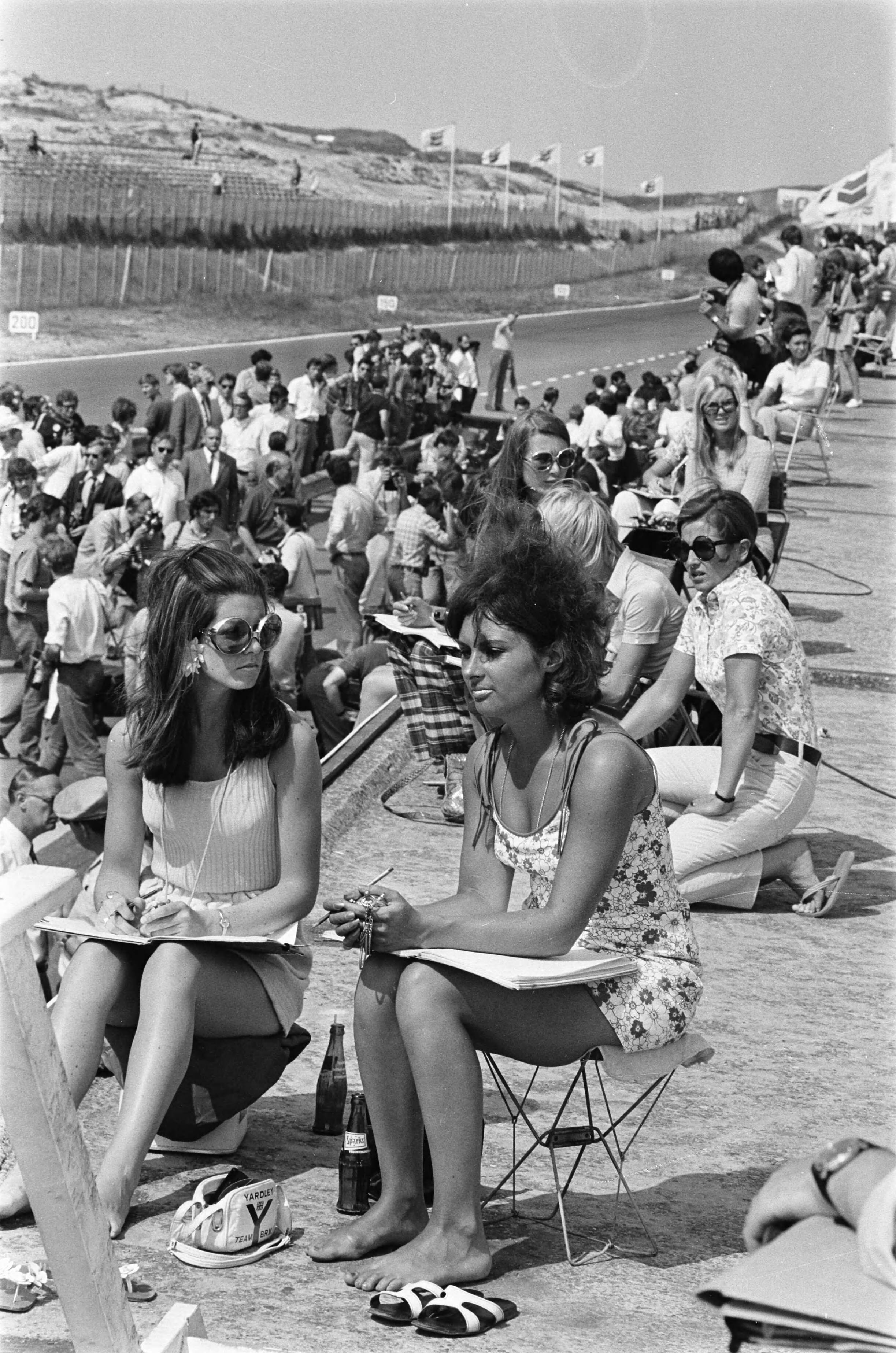 Grand Prix Zandvoort 1970, training — Grand Prix 1970 voor Formule I wagens te Zandvoort; eerste trainingsdag; "Pitspoezen" — Foto: Evers, Joost / Anefo. Licentie: Set B: Rechtenvrij / Publiek Domein. Bron: Nationaal Archief. http://hdl.handle.net/10648/ab9a0322-d0b4-102d-bcf8-003048976d84